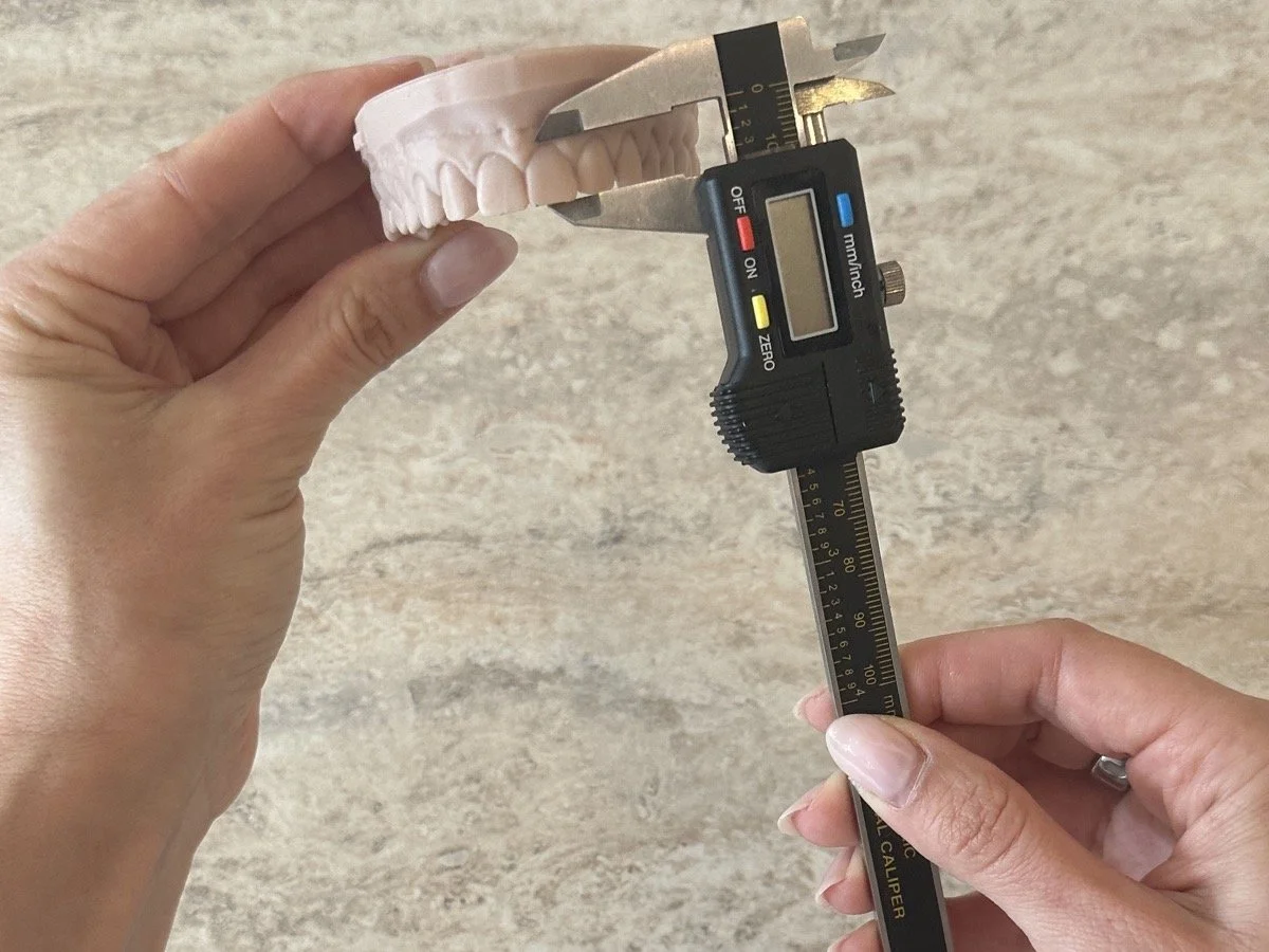 Cosmetic dentistry tools used in smile makeovers at Chicago Aesthetic Dentistry — porcelain veneers shade guide, Invisalign aligners, and professional whitening trays.