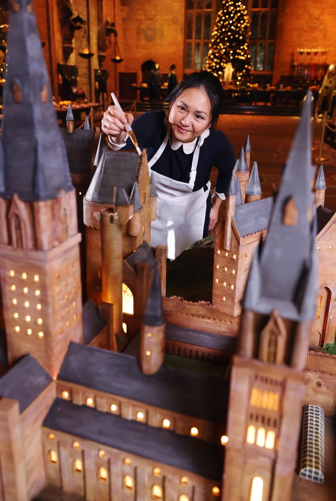 Michelle Wibowo in the background of the Harry Potter's Hogwarts Castle