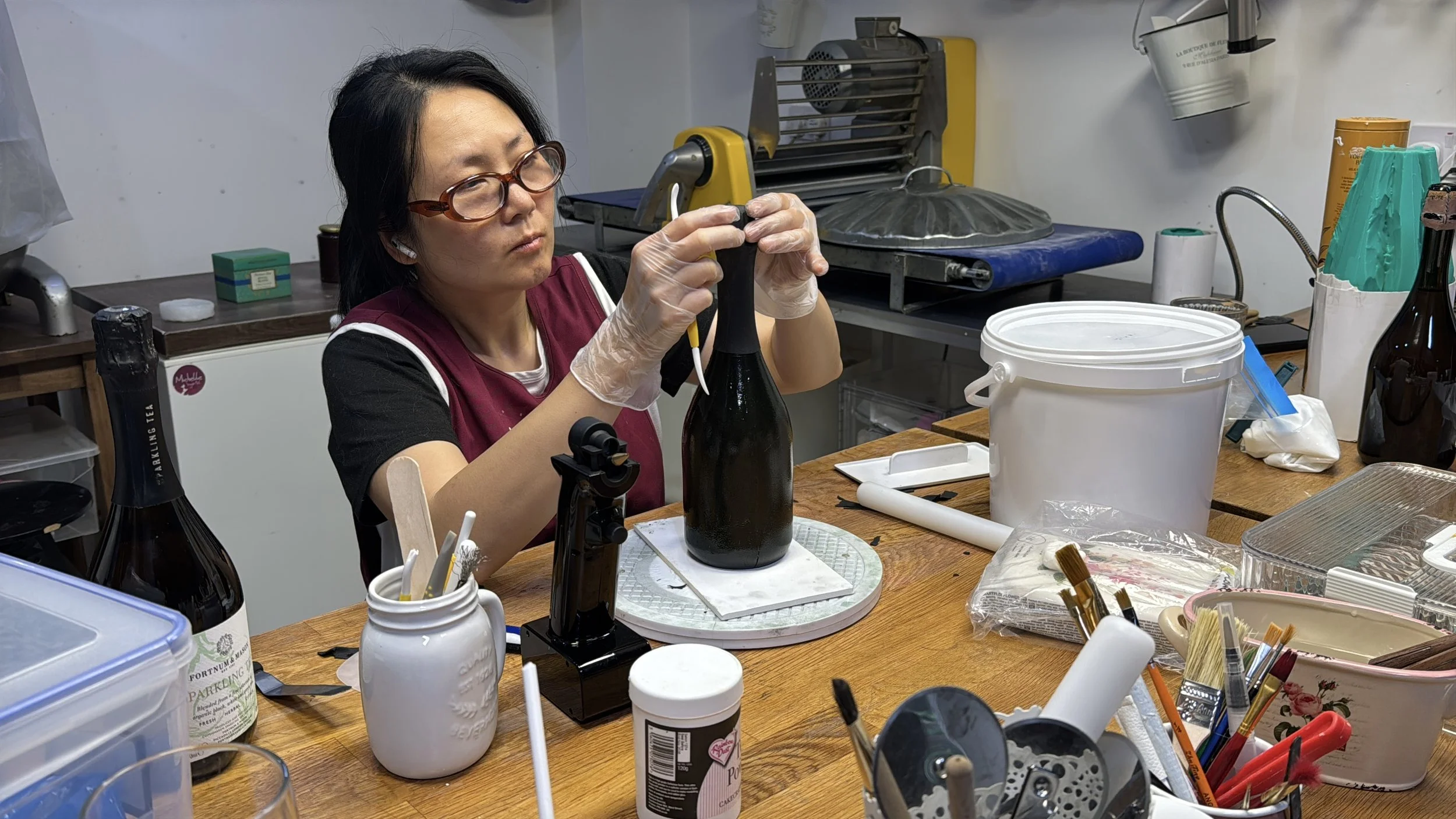 Food artist Michelle Wibowo working on the finer details of a wine bottle moulded from sugar