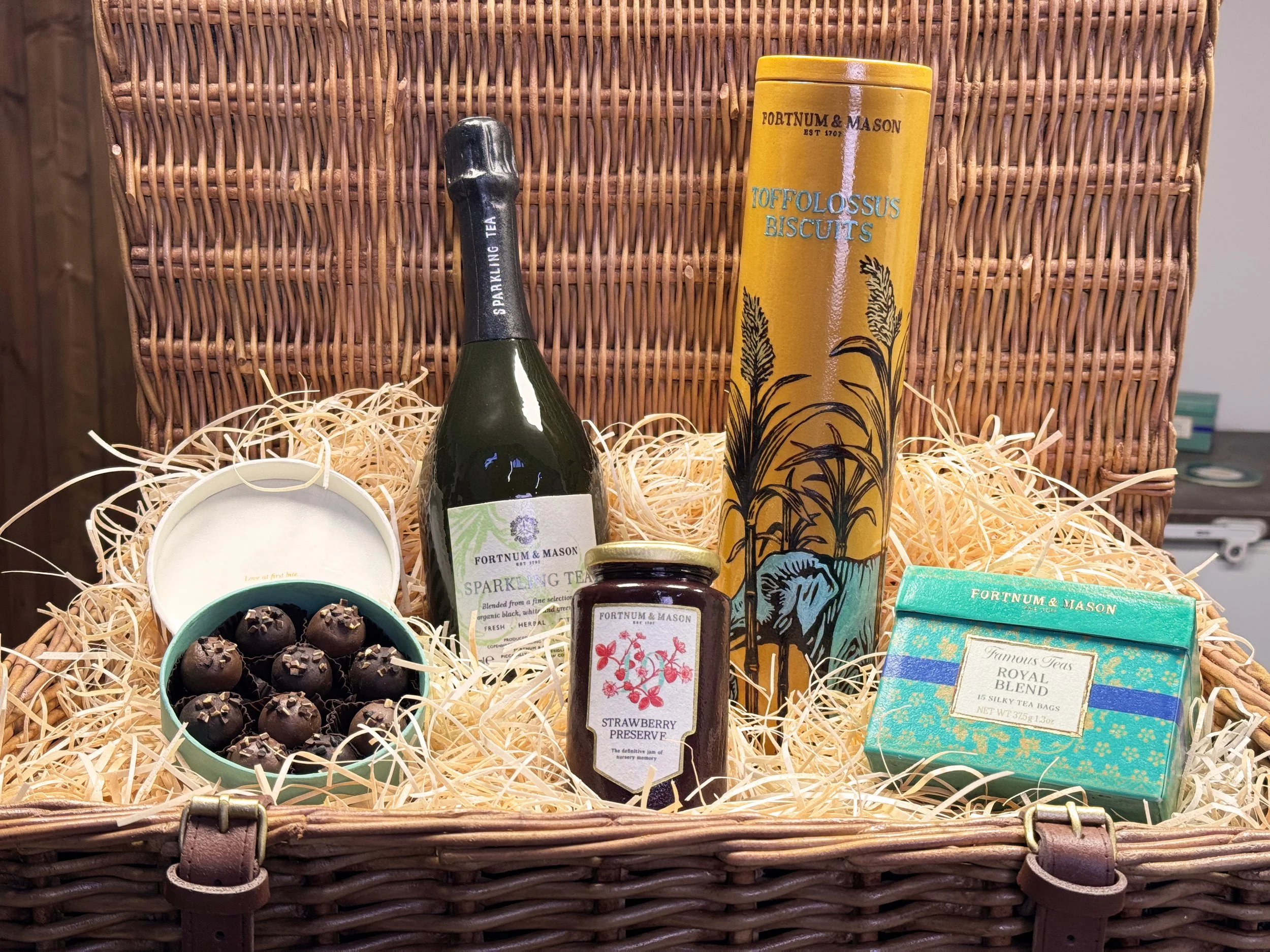 An intricate sugar-sculpted hamper and its contents complete with a bottle, chocolate truffle box, and biscuit tin.