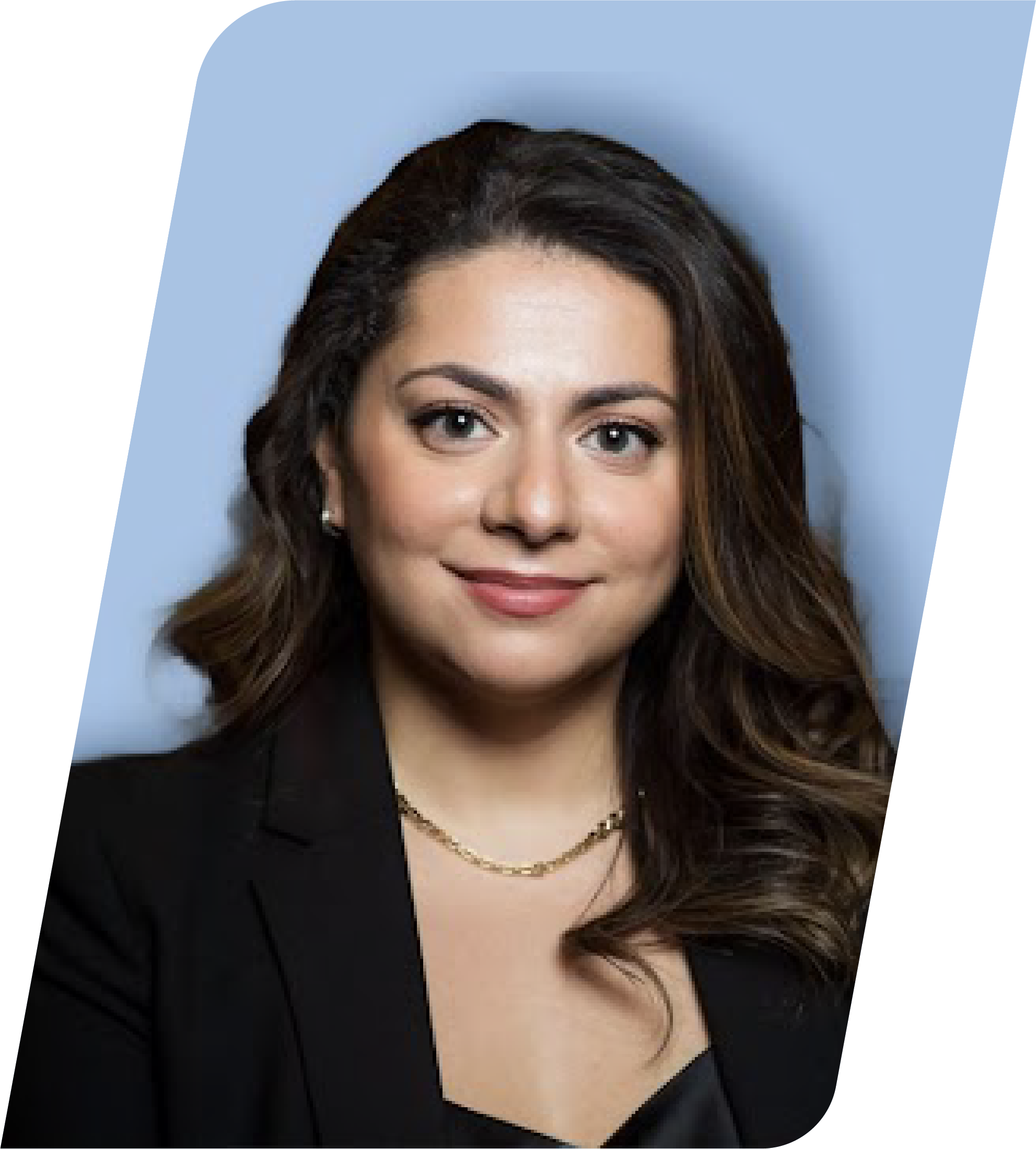 A professional woman with long brown hair, wearing a black blazer and gold jewelry, smiling against a blurred blue background.
