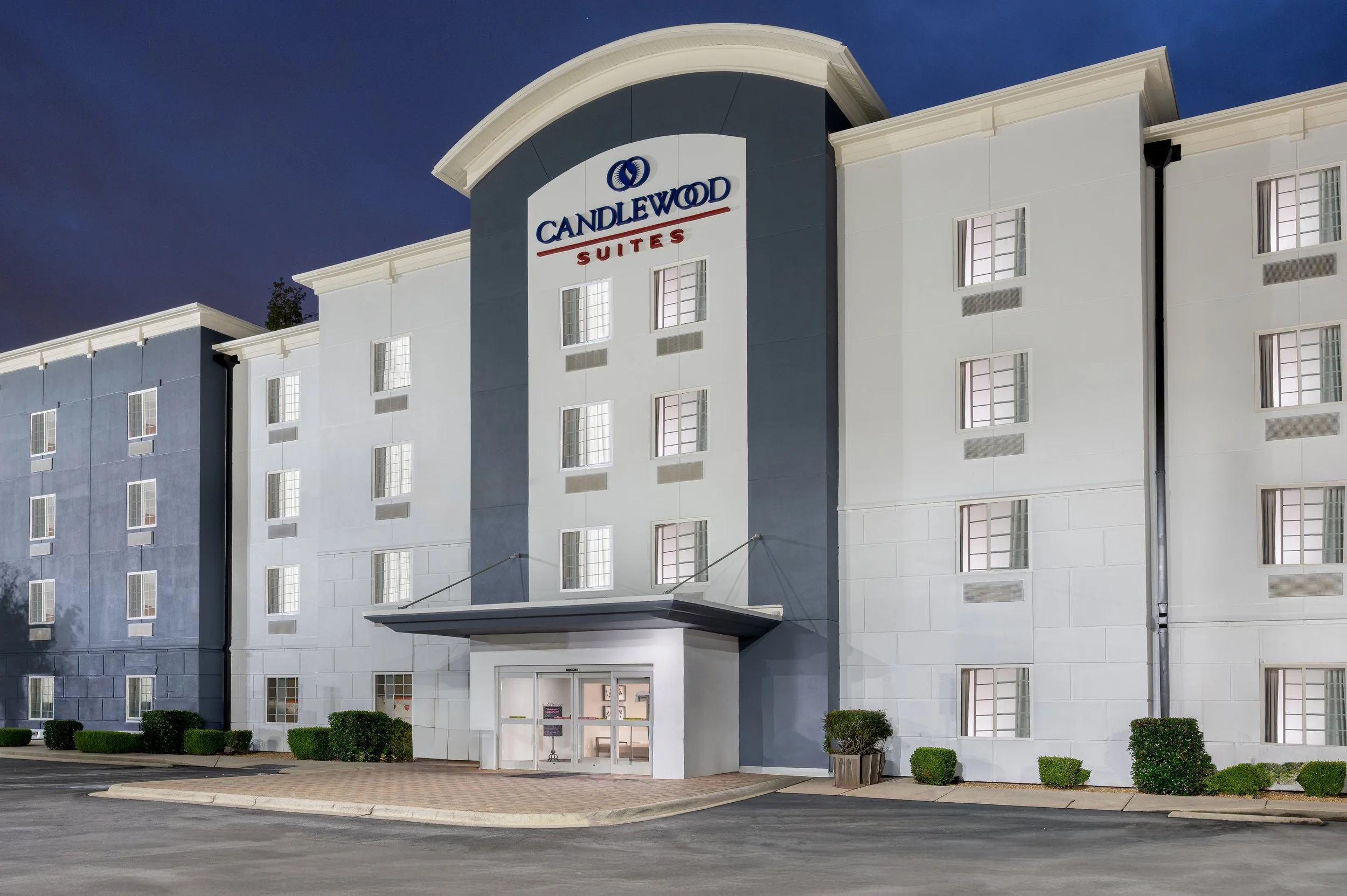 Candlewood Suites hotel building with multiple floors and a palm tree in front.