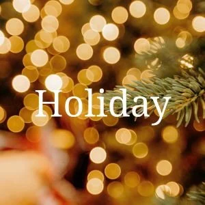 Blurred holiday lights with a Christmas tree branch in the foreground and the word 'Holiday' overlaid.