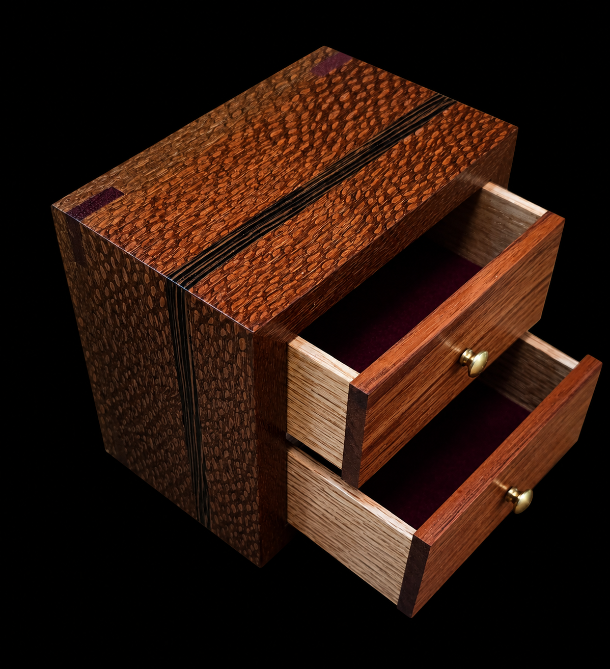 A small wooden jewelry box with two open drawers, made from various types of wood, set against a black background.