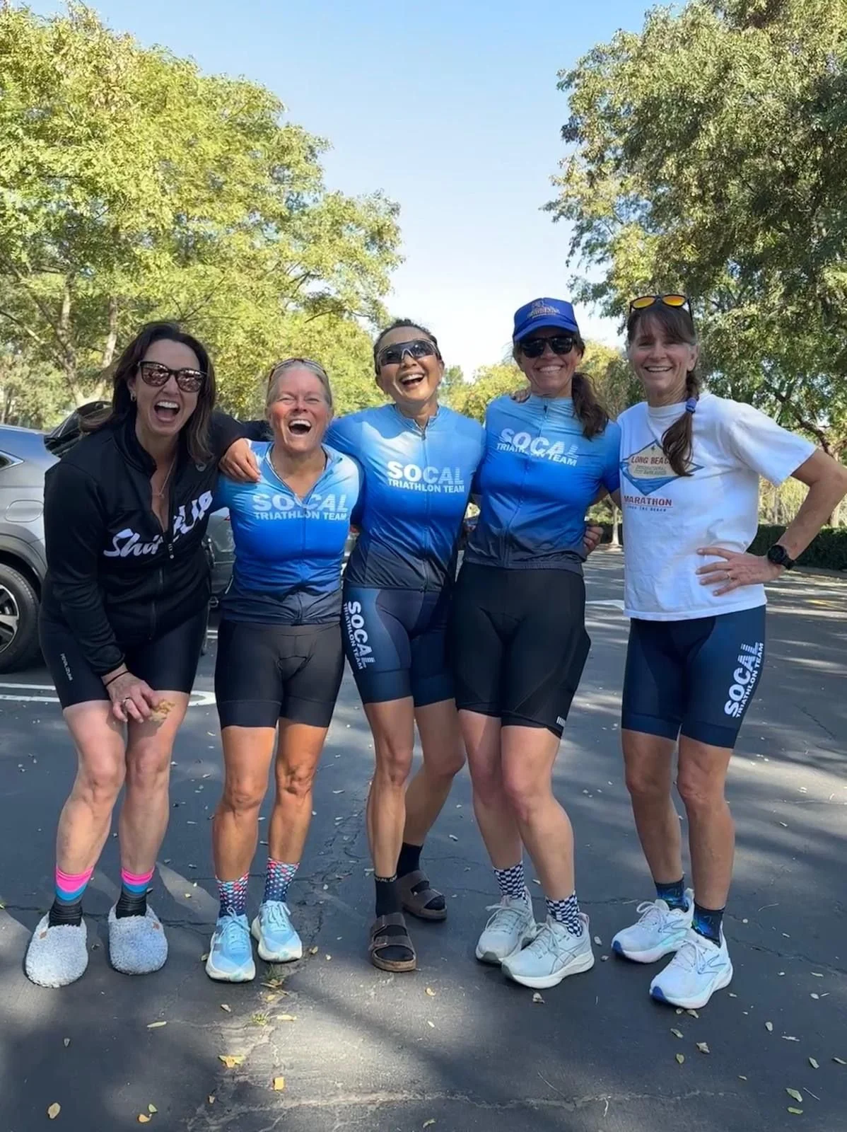 Irvine Orange County Triathlon Team women on Saturday group bike ride, February 2026. Teammates laughing and smiling while building base miles for Ironman 70.3 Oceanside.