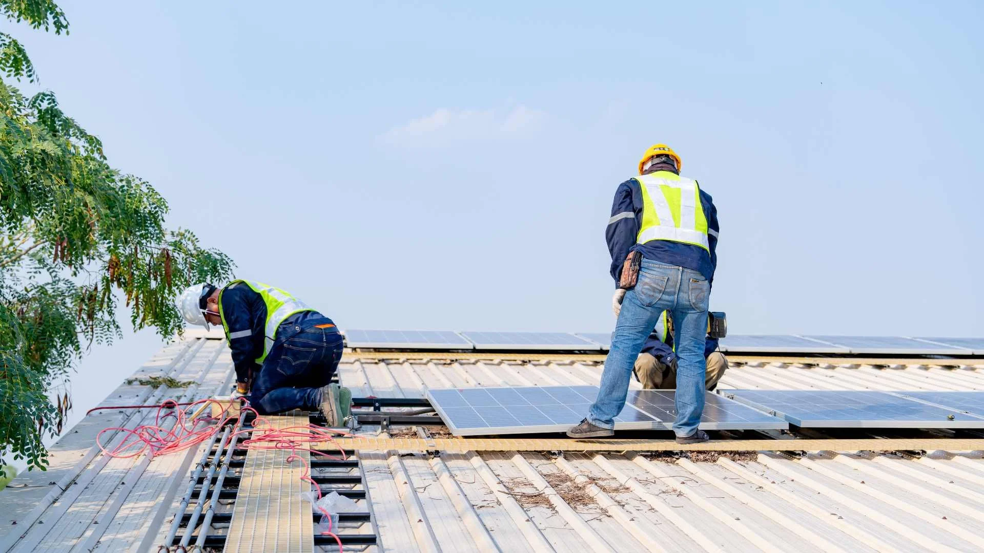 some professional roofing contractors working on roof that is not asphalt but metal
