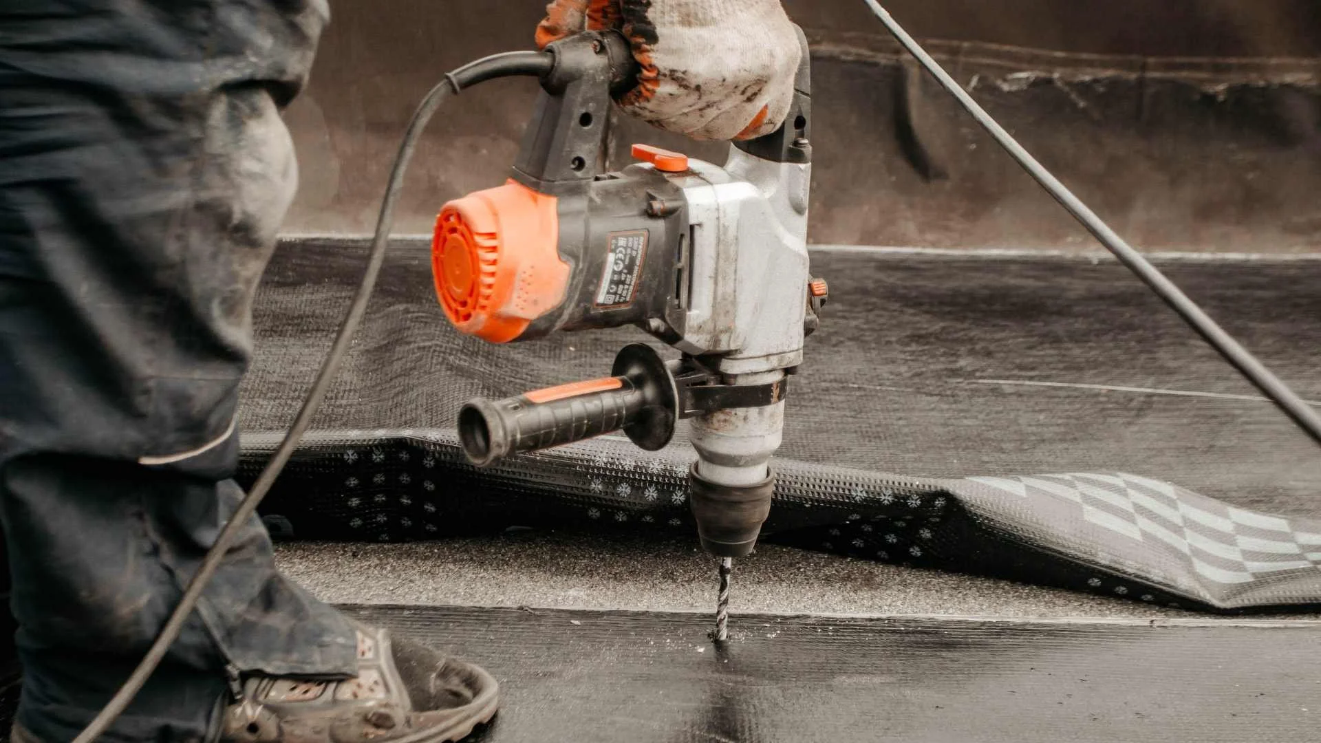a roofer using a drill on a commercial roof in alabama