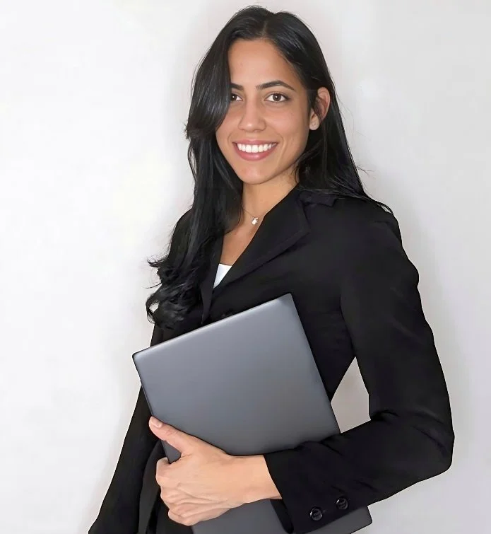 Woman in a black suit holding a laptop, smiling