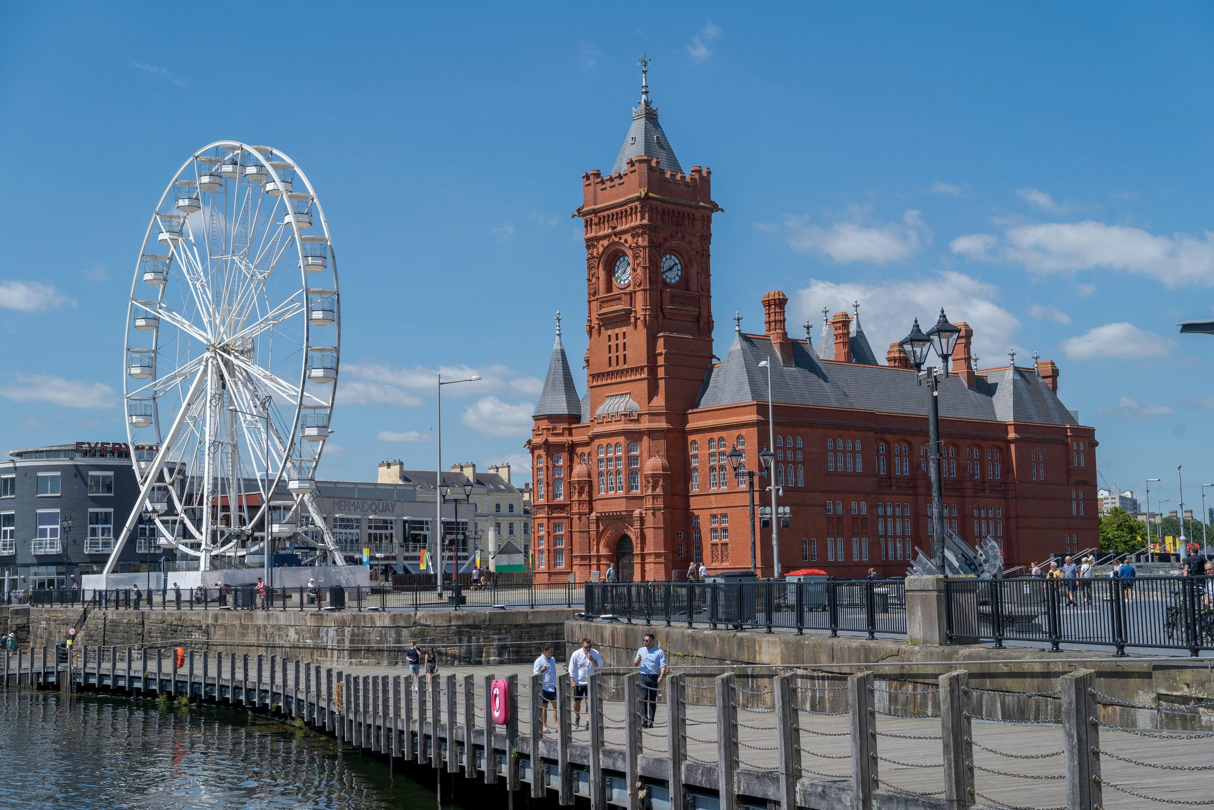a_ferris_wheel_and_red_building_against_a_blue_sky