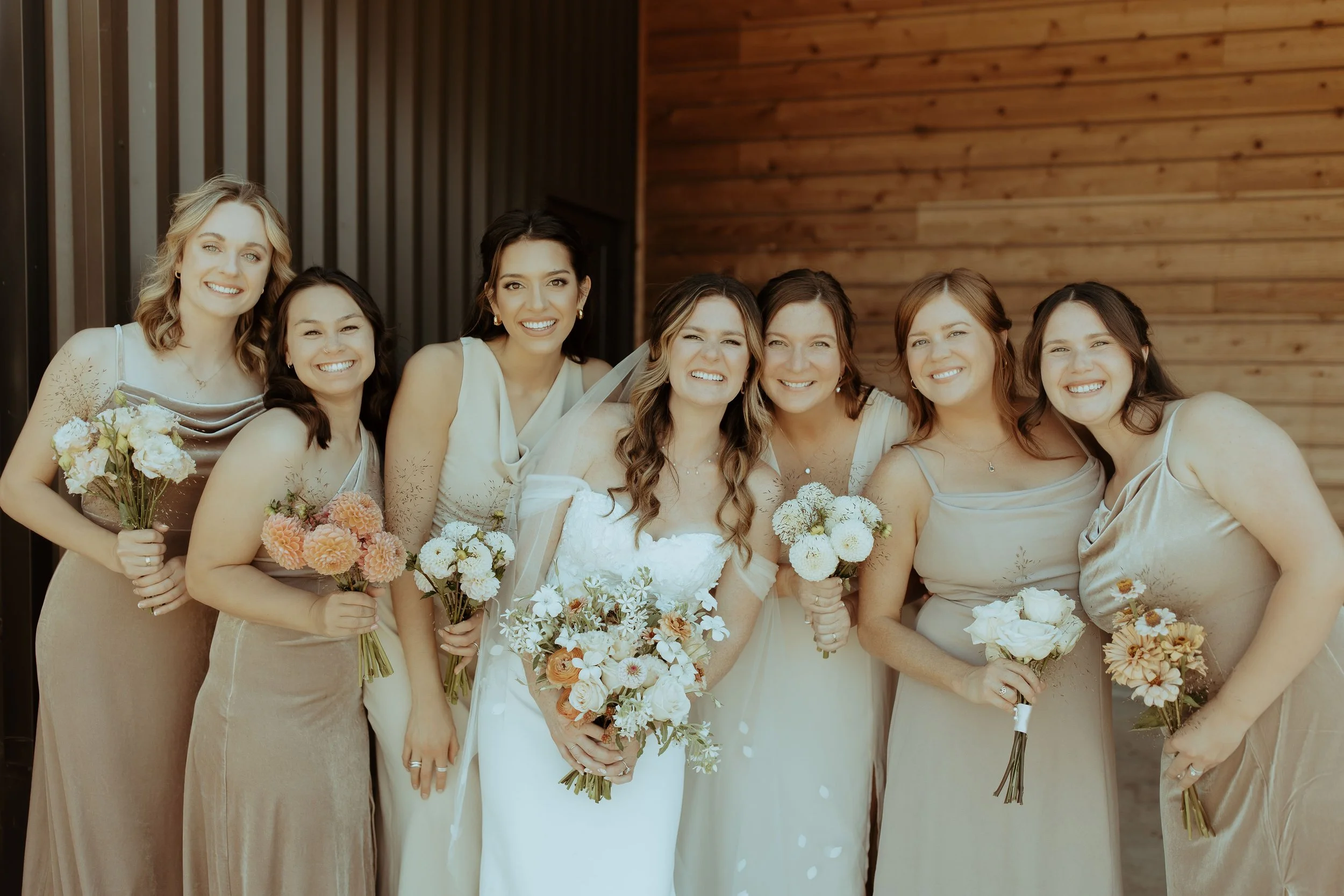 Bride and her bridesmaids holding bouquets made from locally grown summer blooms.