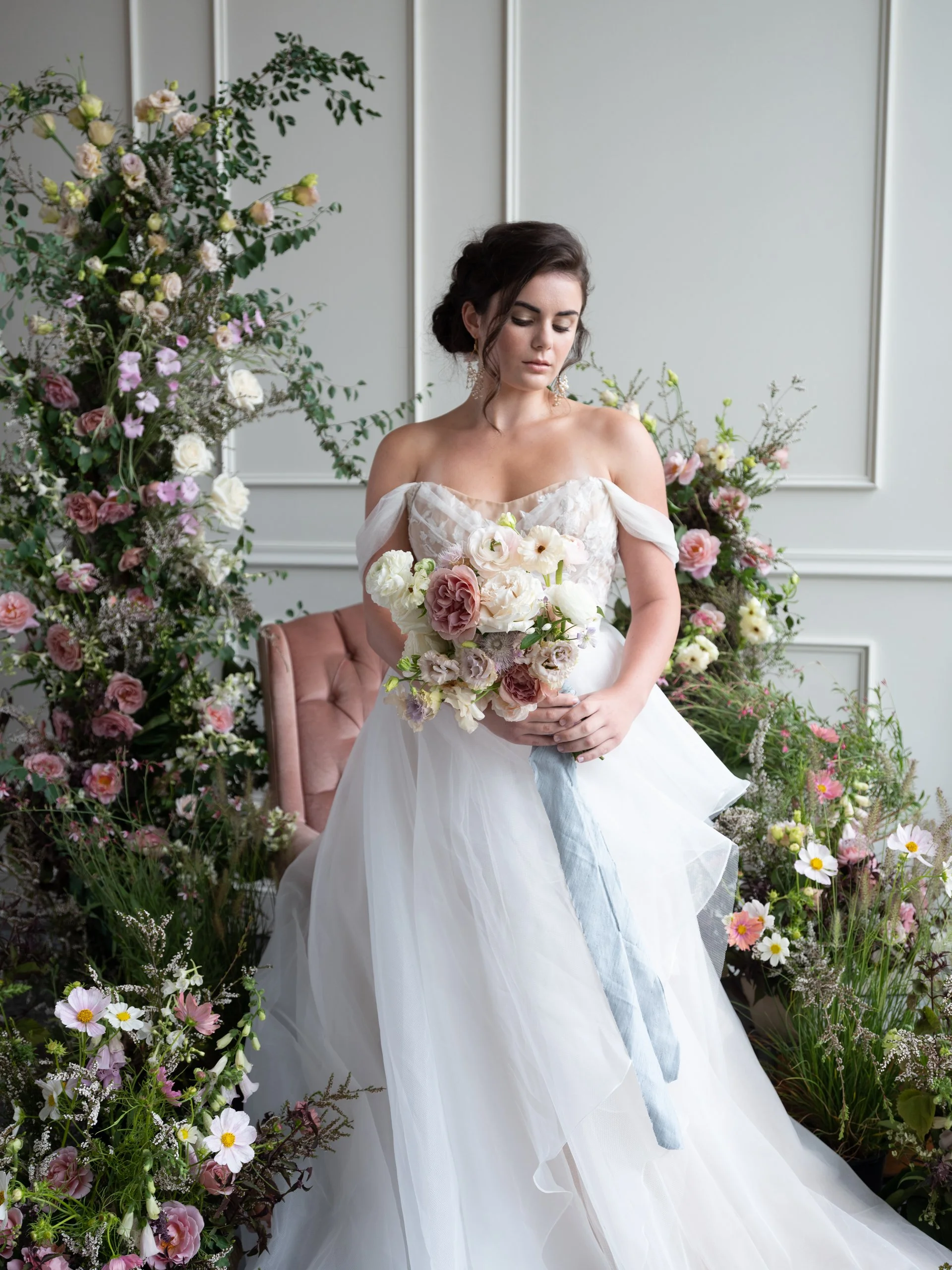 Editorial wedding portrait with a bride in an off-the-shoulder wedding dress holding a blush and ivory floral bouquet, shot at Tendue in Portland.