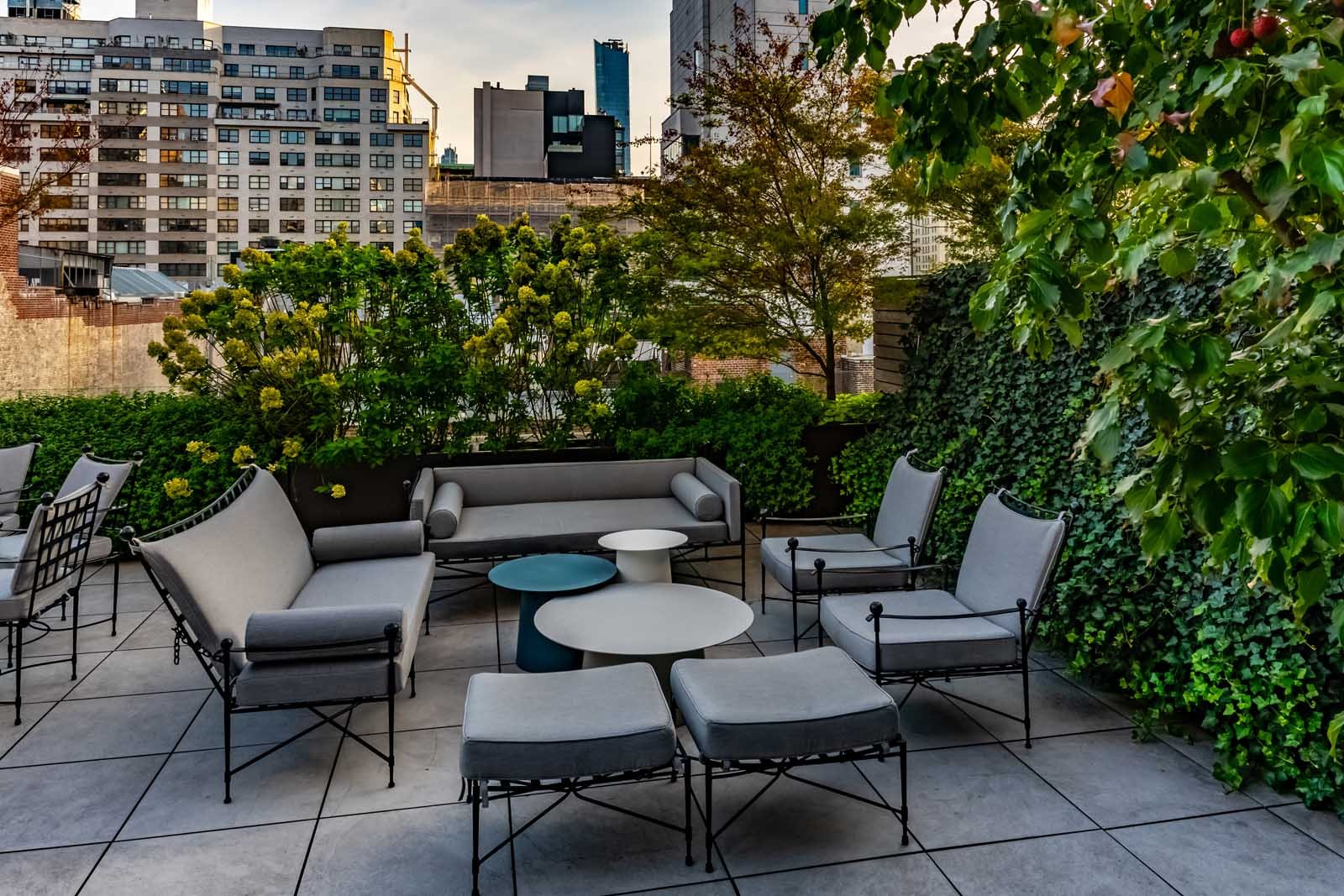 NYC rooftop patio with lounge seating and lush green wall