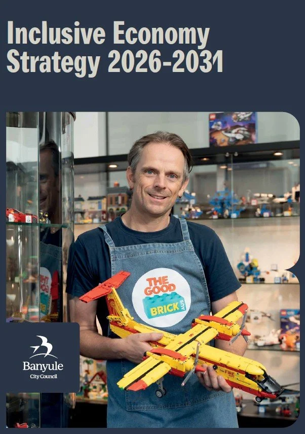 Banyule City Council Inclusive Economy Strategy 2026-2031 front cover. Image of a person holding a Lego airplane from the social enterprise The Good Brick.