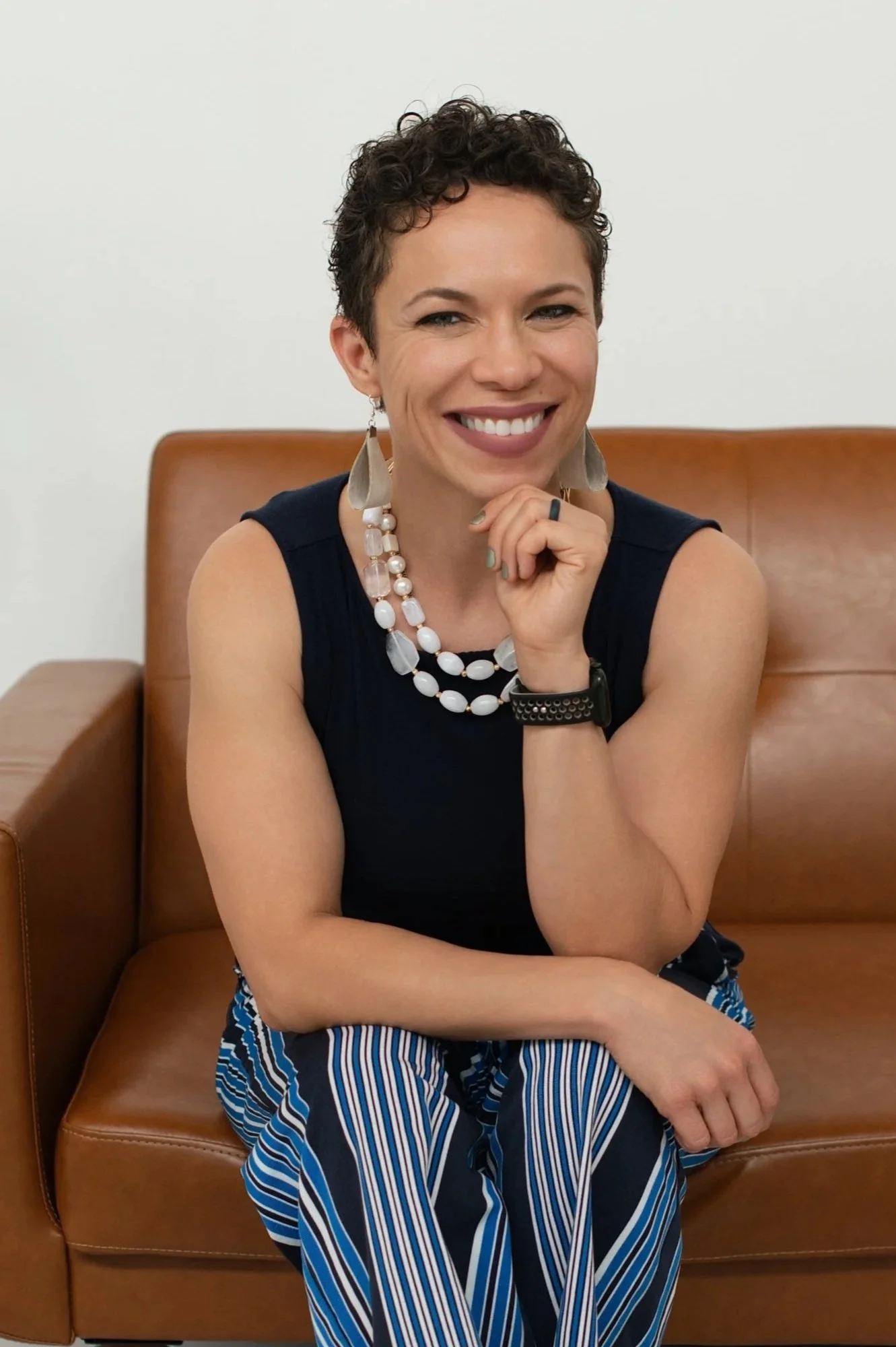 Dr. Angela Andrews, lifestyle medicine physician, sitting on a couch