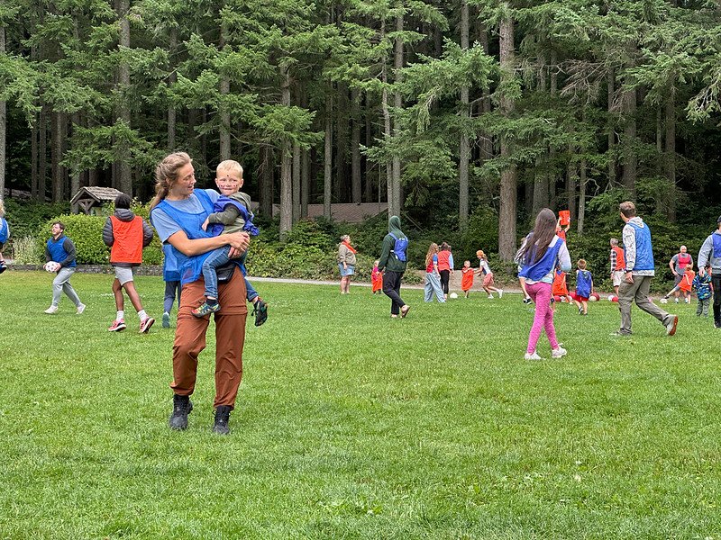 Outdoor group activity in a forested park with adults and children