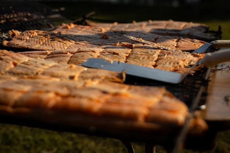 Salmon filets being grilled on an outdoor barbecue.