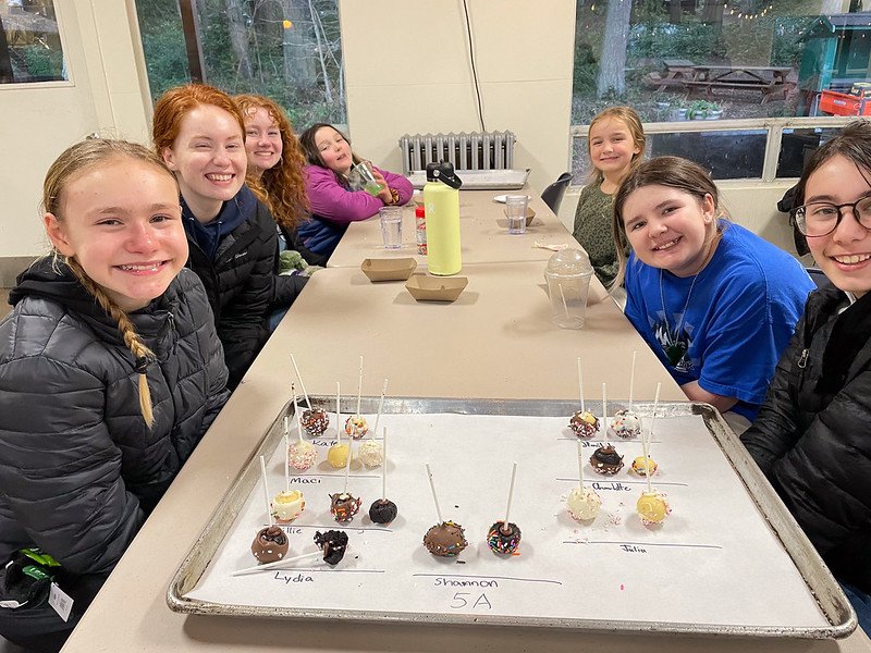 Group of smiling kids around a table with cake pops