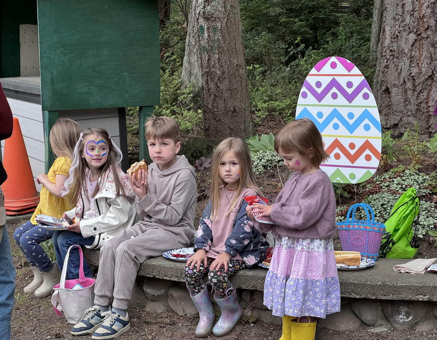Young kids eating and looking at Easter eggs.