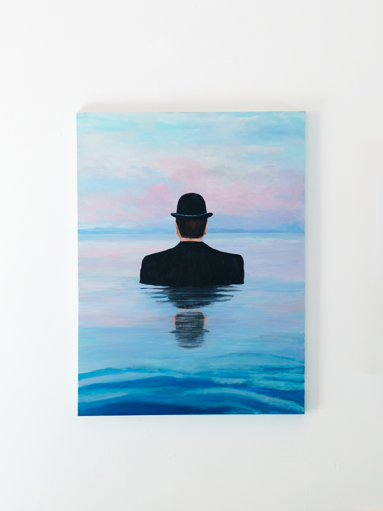 NO MAN IS AN ISLAND
Tom Blood
Acrylic on canvas
30x40 | $2,090

A man in a bowler hat is standing still in what appears to be a lake or perhaps a sea. It's unclear how he got there or what he's doing. The calm water and pastel sky evoke peace, while 