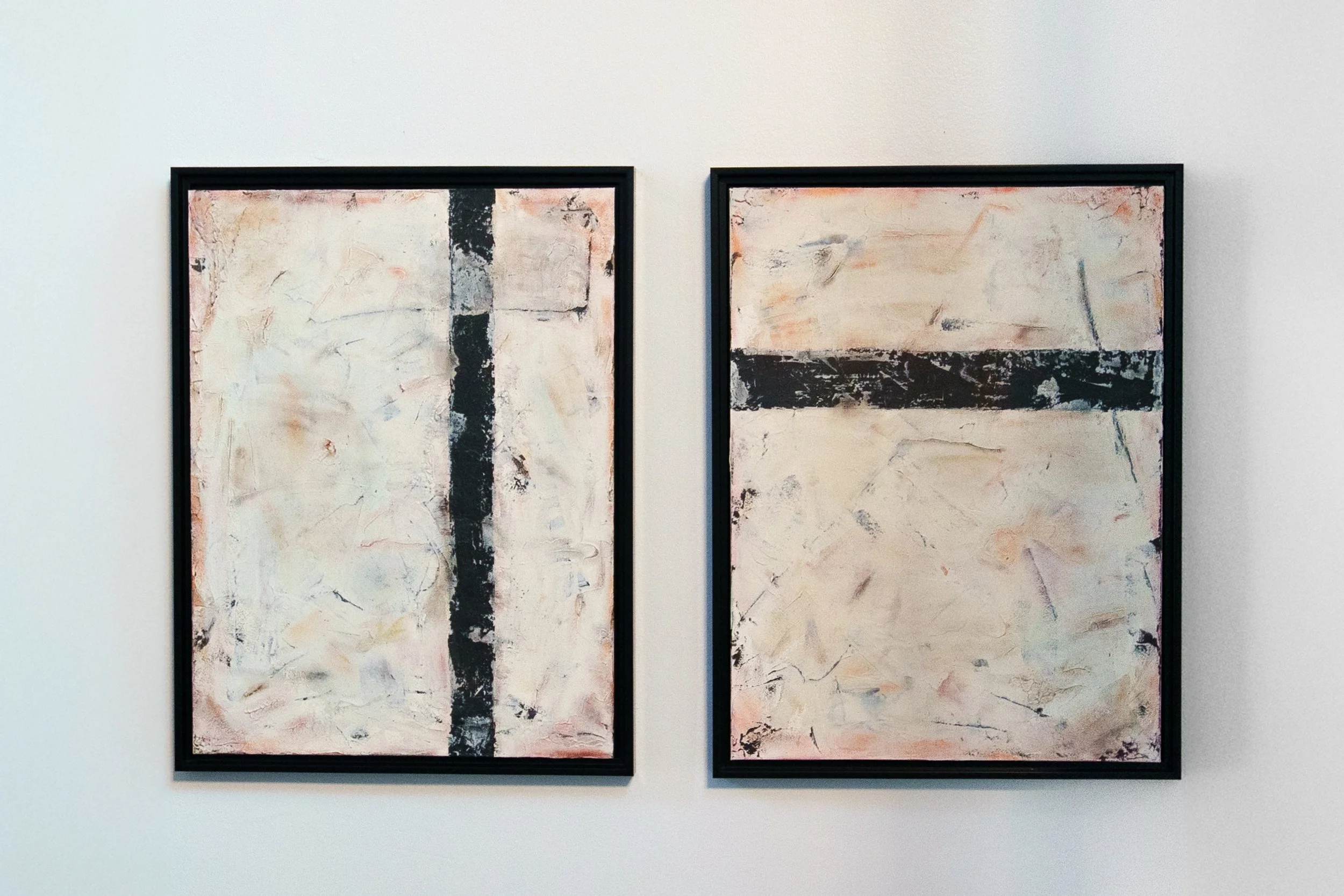 Two abstract paintings with black horizontal and vertical stripes, framed in black, hung on a white wall.