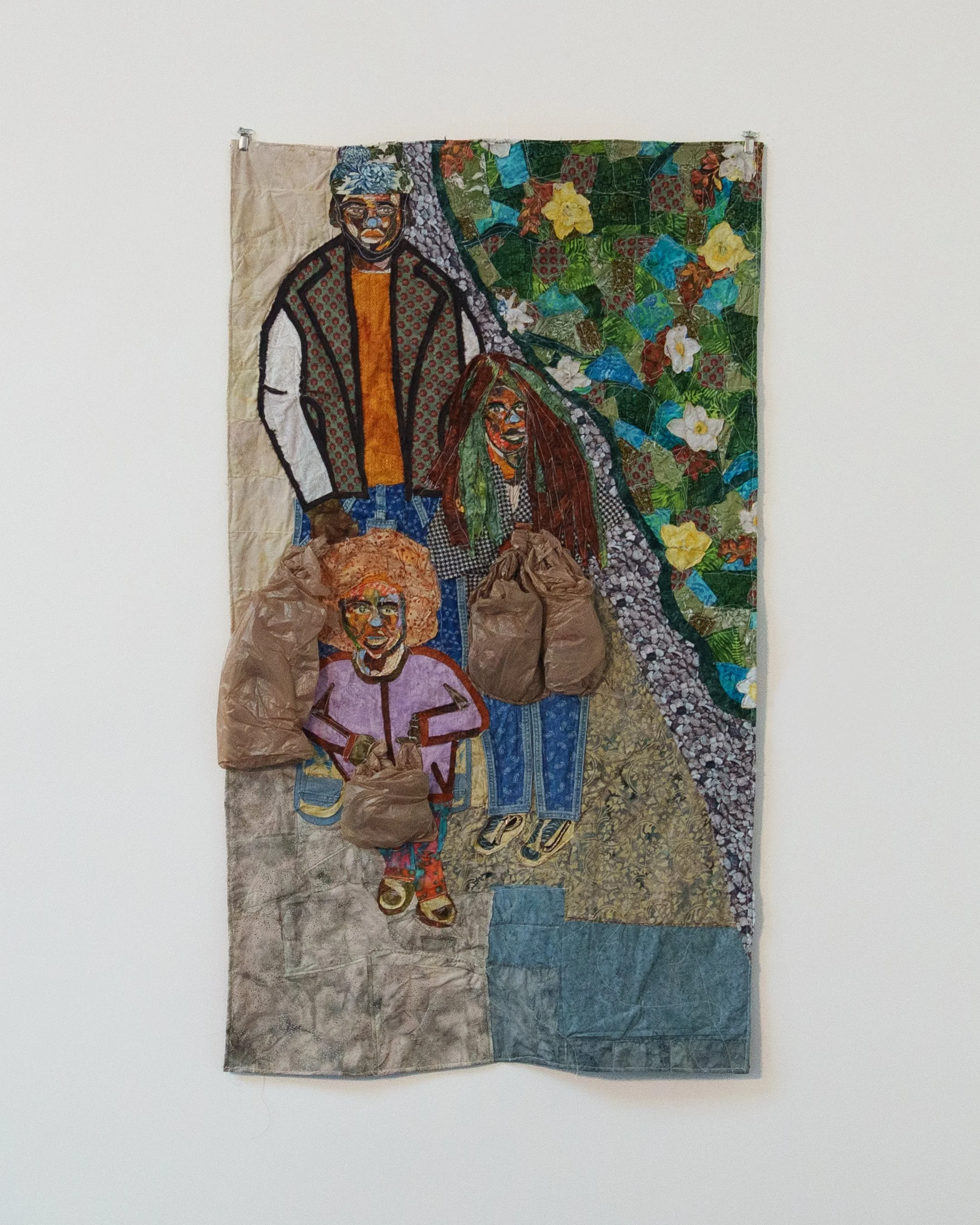 Textile artwork depicting four colorful individuals, with two carrying brown paper bags, against a vibrant, floral and patterned background.