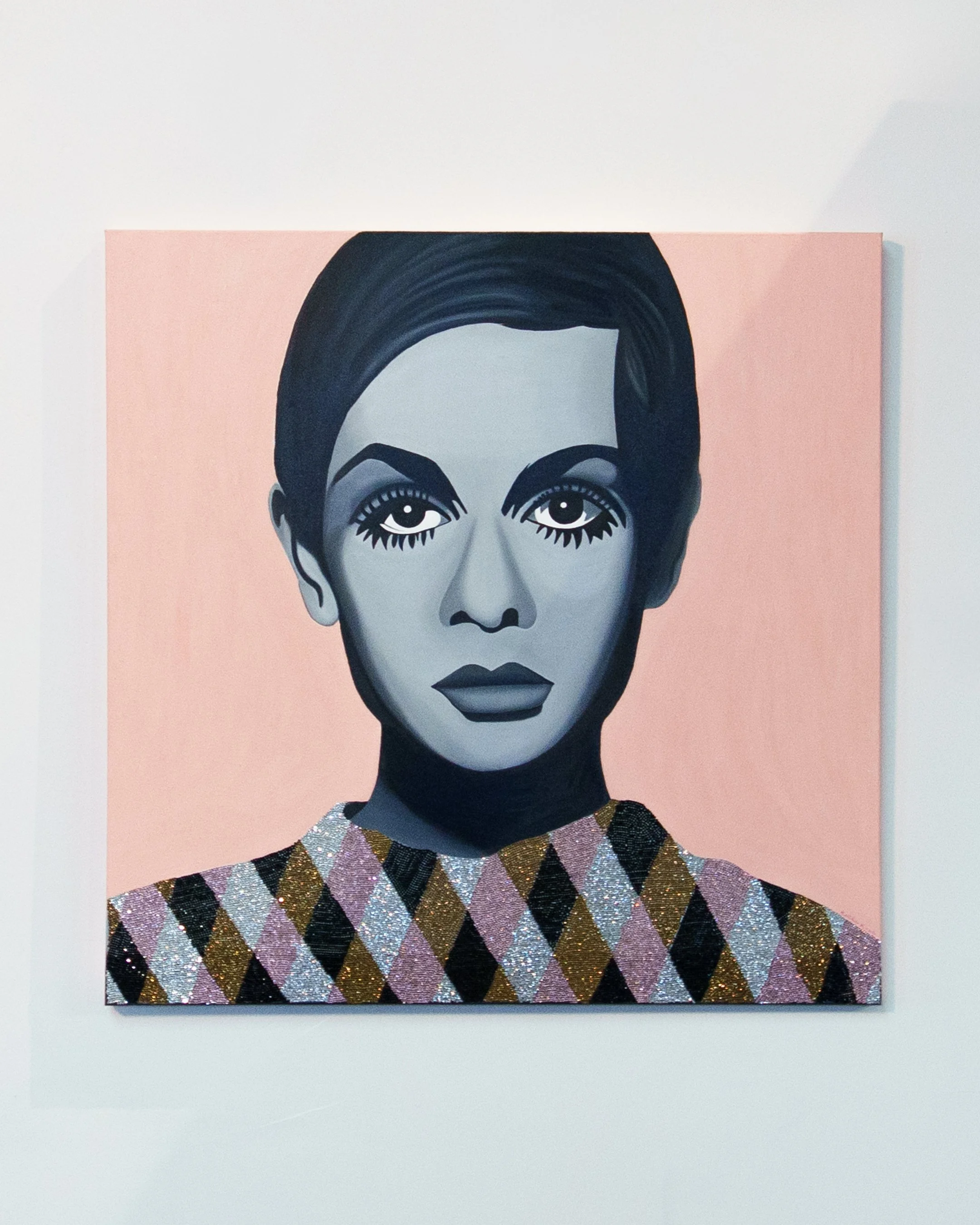 Painting of a woman with dark hair, intense eyes, and dark lipstick, wearing a colorful patterned top, against a pink background.