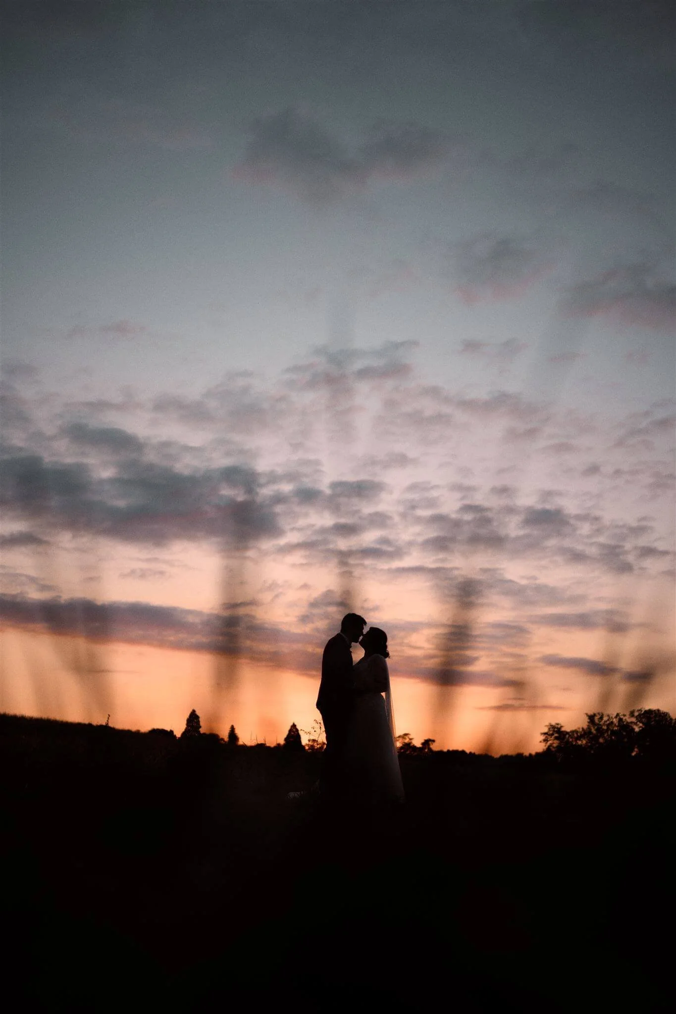Silhouette d'un couple qui s'embrasse lors d'un coucher de soleil avec un ciel orageux