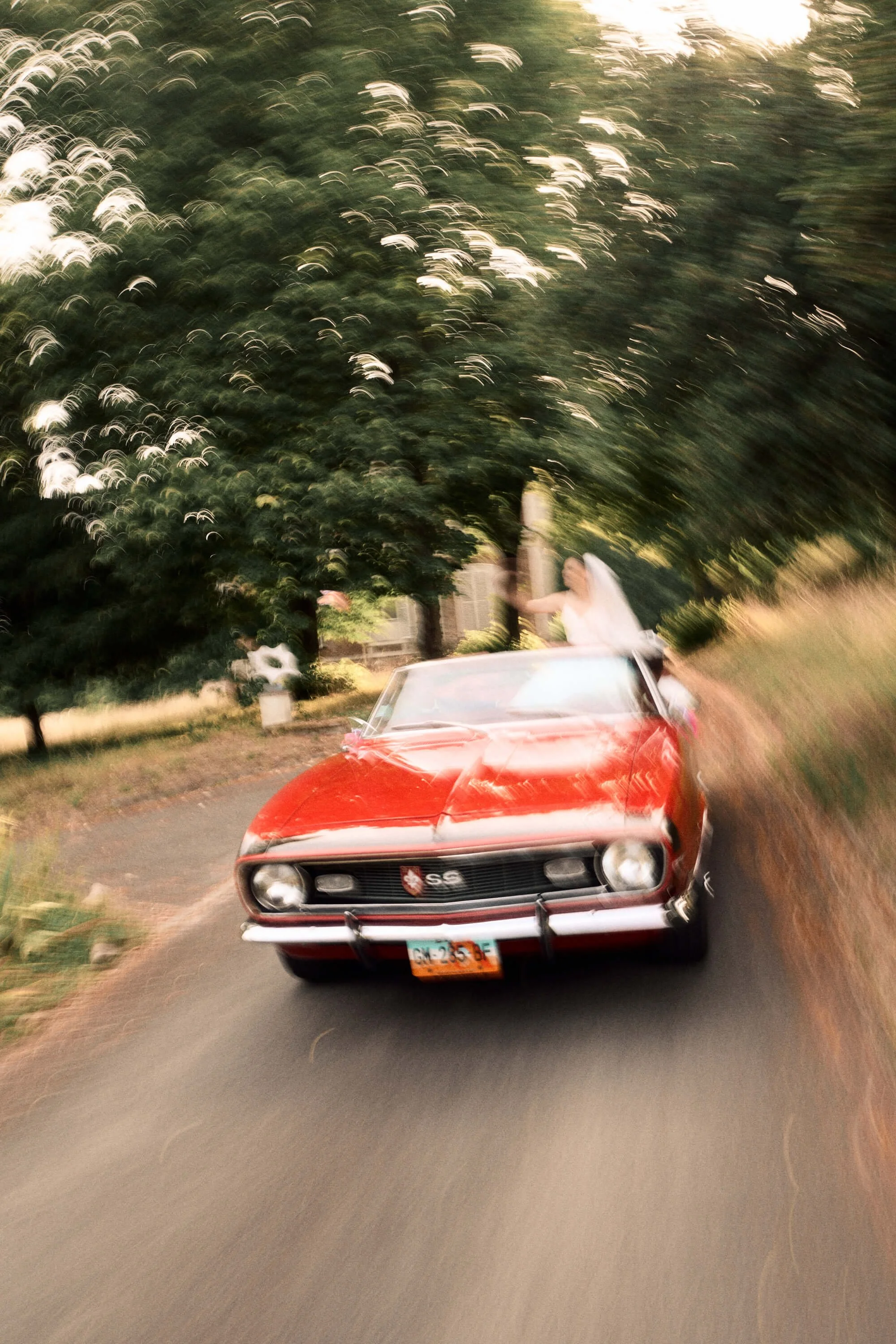 Un couple en voiture de sport vintage pendant leur mariage