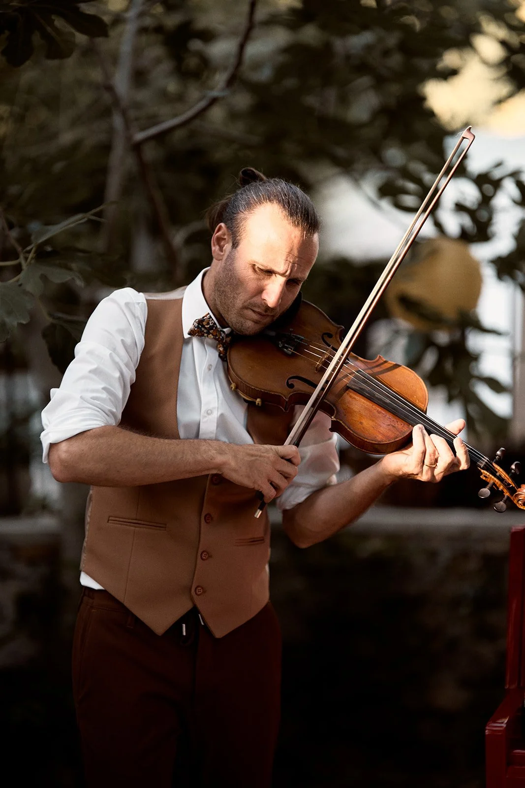Un homme qui joue du violon lors de son mariage pour sa femme