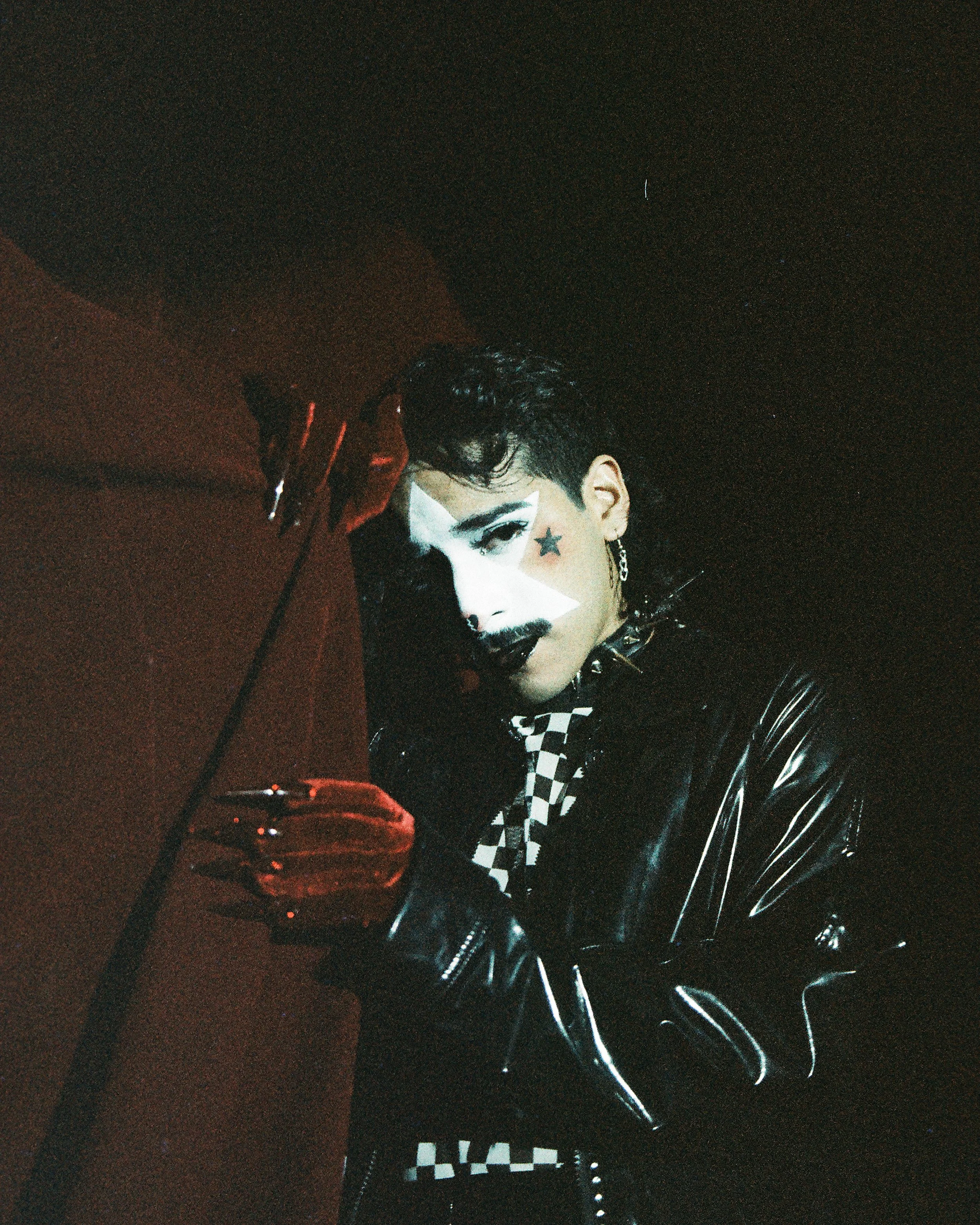 Image of a drag artist against a red curtain shot on film at Purgatory Bar