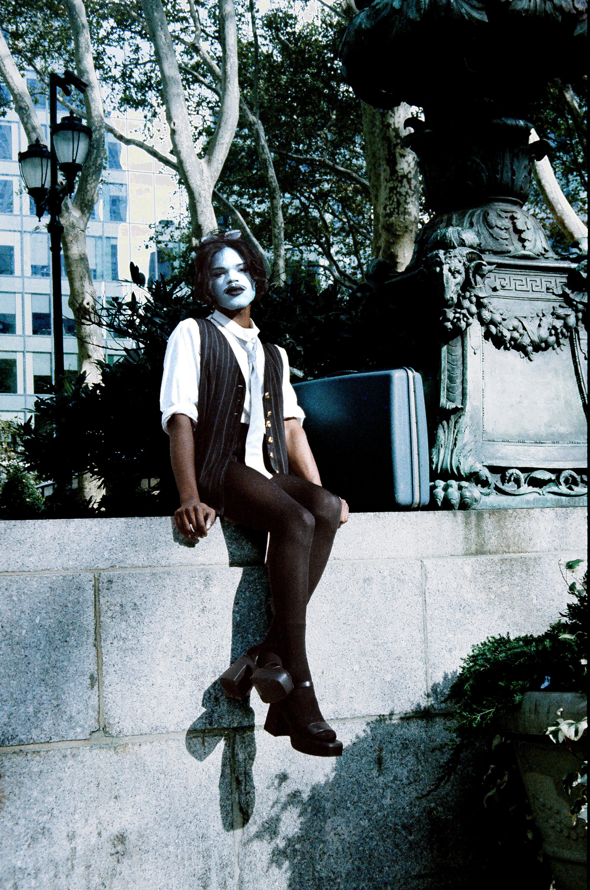 Image of a drag artist sitting on a wall in New York City shot on film