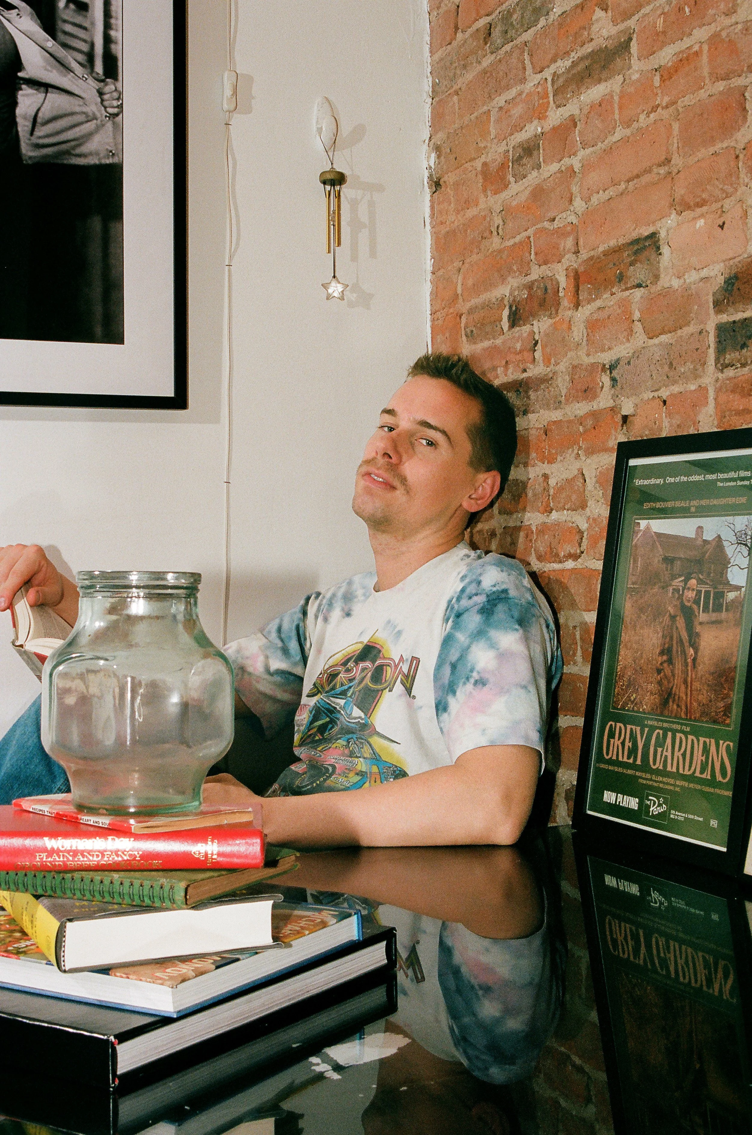 Image of a boy in his kitchen with books and a brick wall shot on film