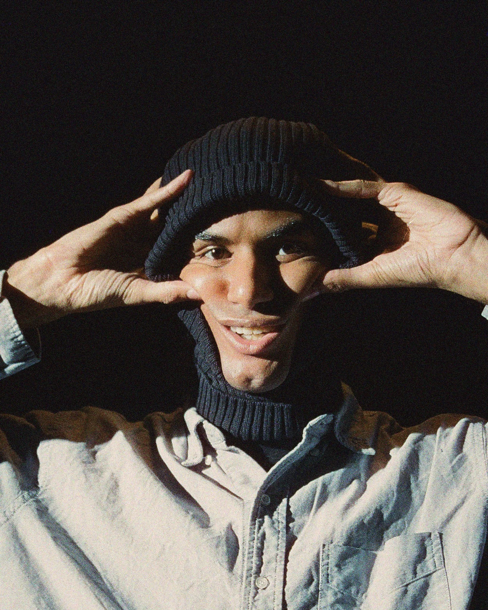 Self portrait of voxigma wearing a black hat with contrasting lighting on digital