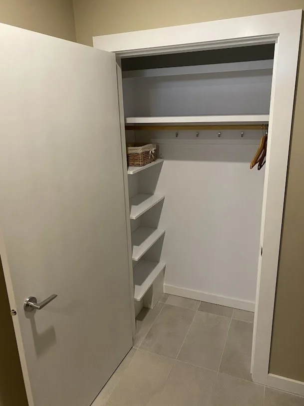newly renovated closet painted in beige with sand color ceramic tile floor installed by a Vancouver professional carpenter