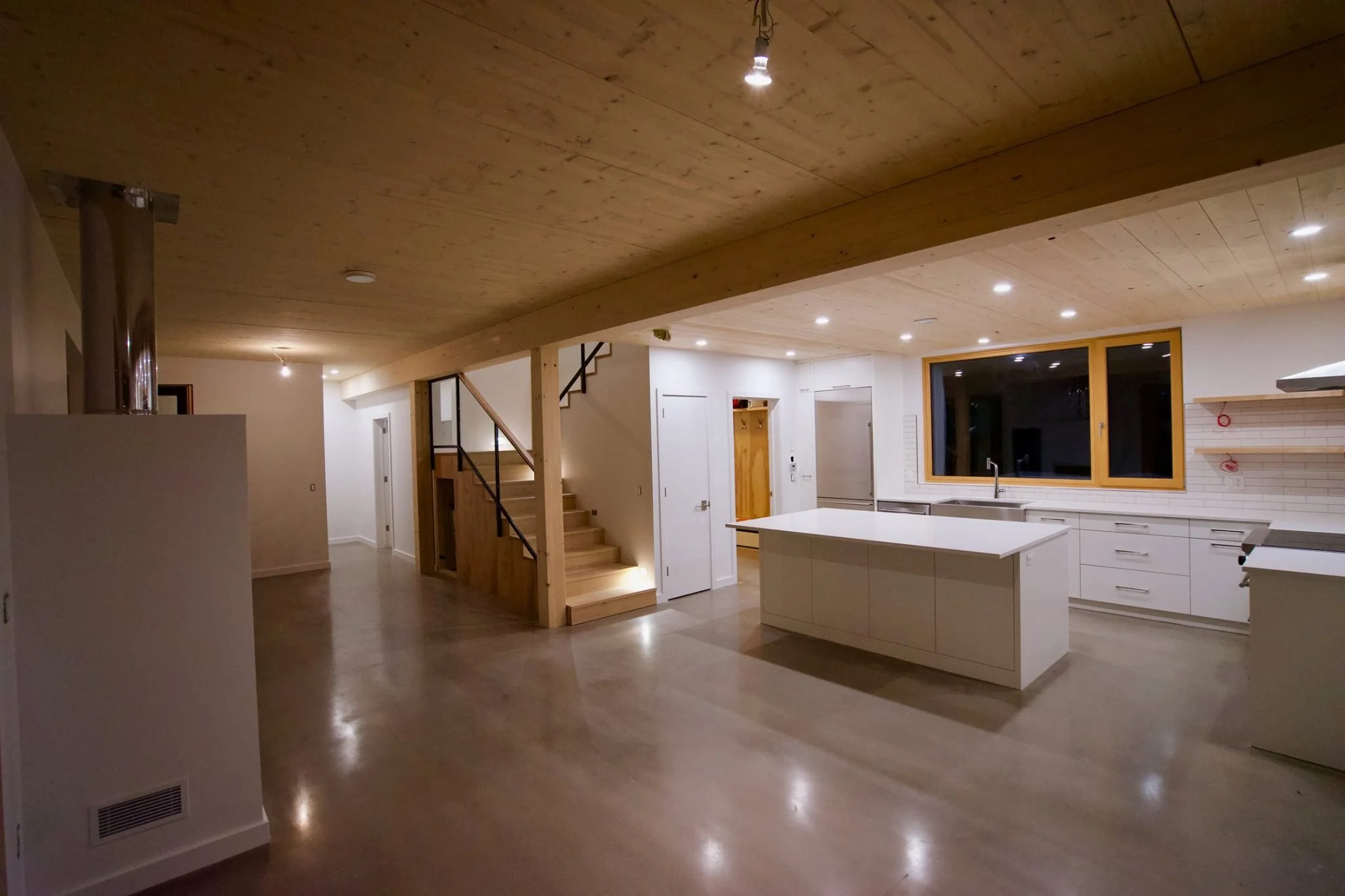 all white cupboard custom carpentry in a basement with wooden floor in a modern house
