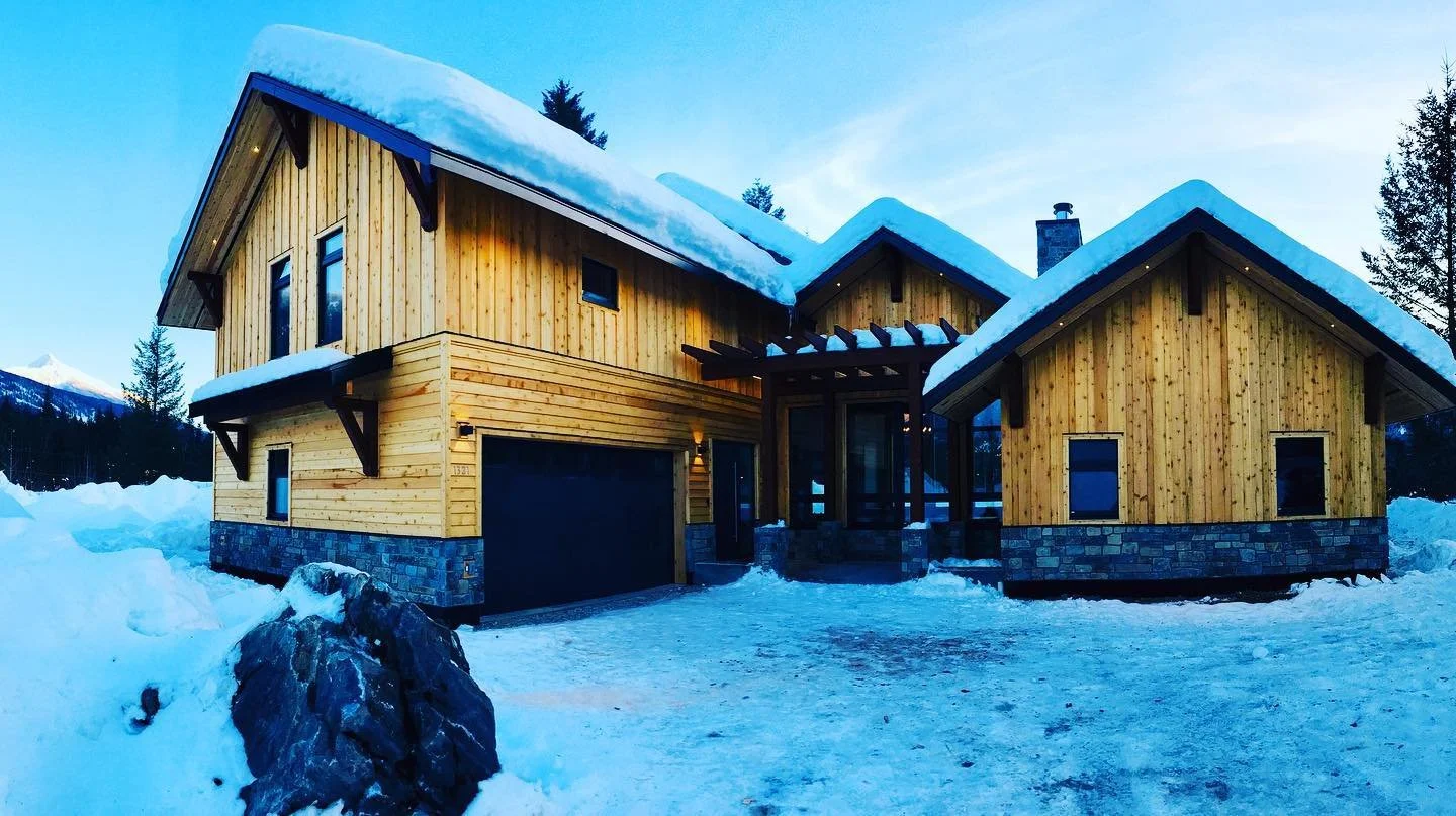 Luxurious wooden wall cladding house with a garage over a snowy landscape in Squamish built by a expert custom carpenter