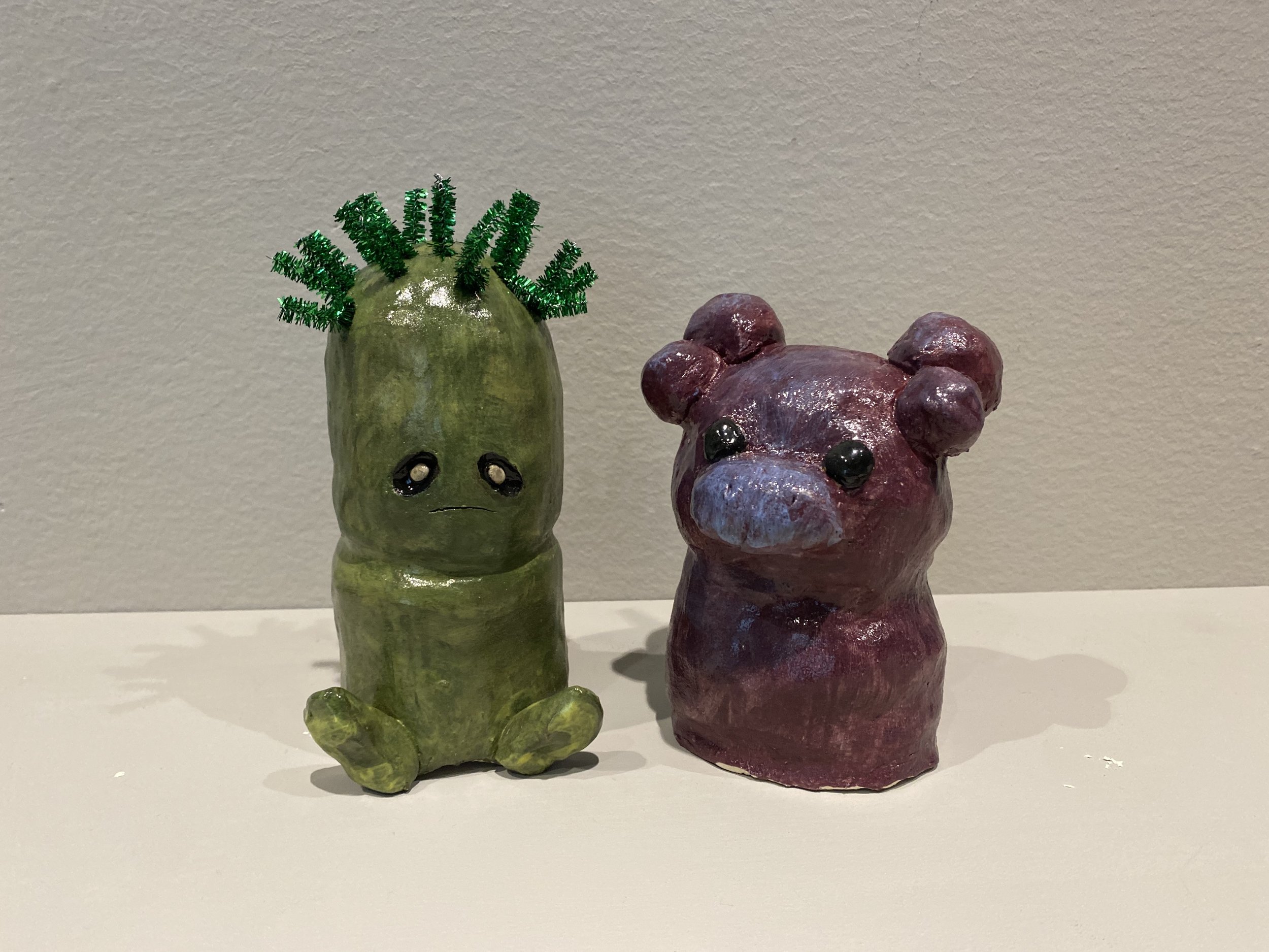 Ceramic figures painted with underglazes and adorned with pipe cleaners.