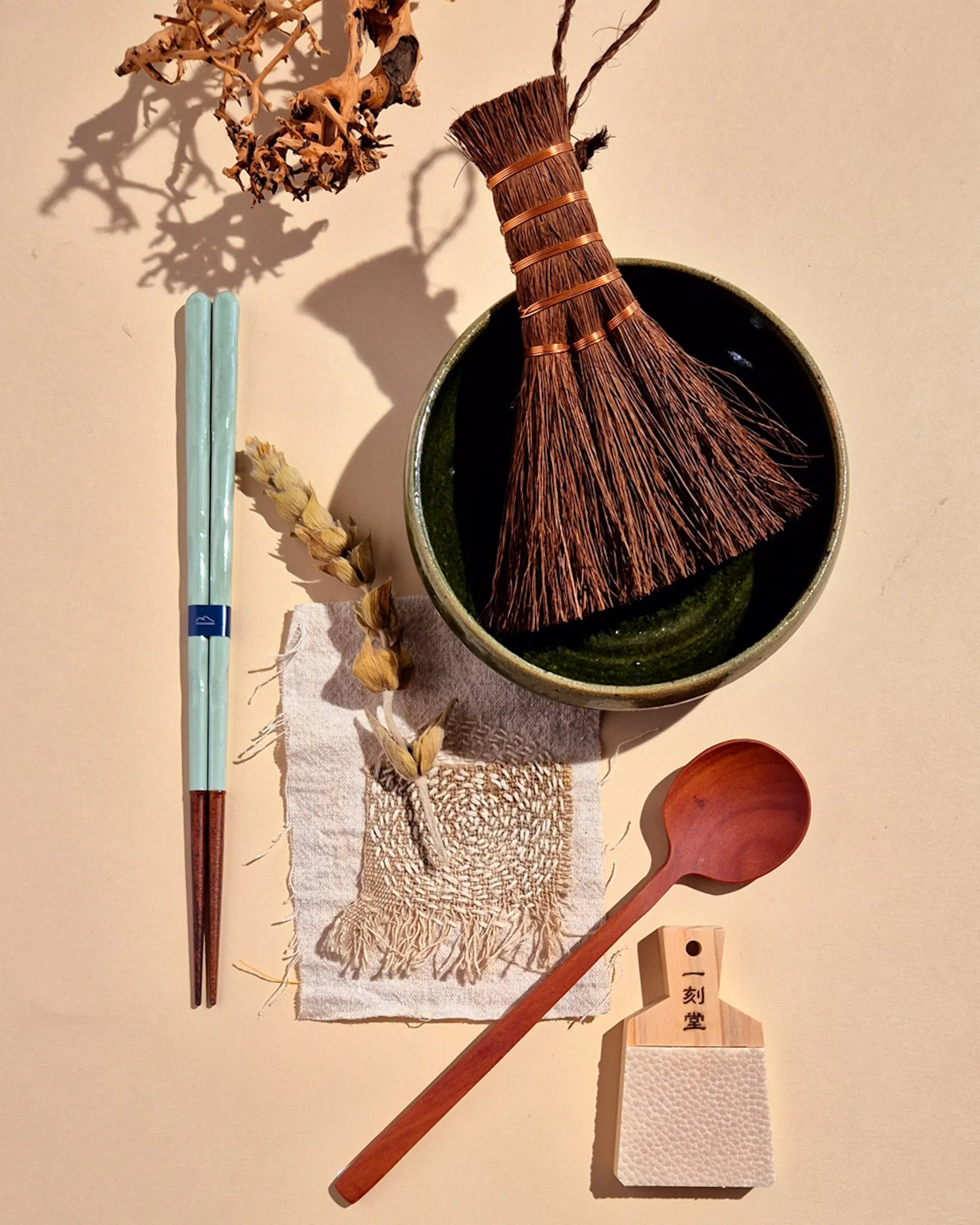 Minimal Japanese tabletop styling with tray, incense box and natural wood displayed on a beige background.