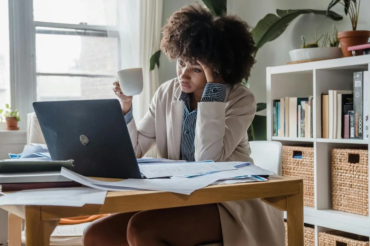 Professional woman at desk with coffee looking tired — high-functioning anxiety in Christian women