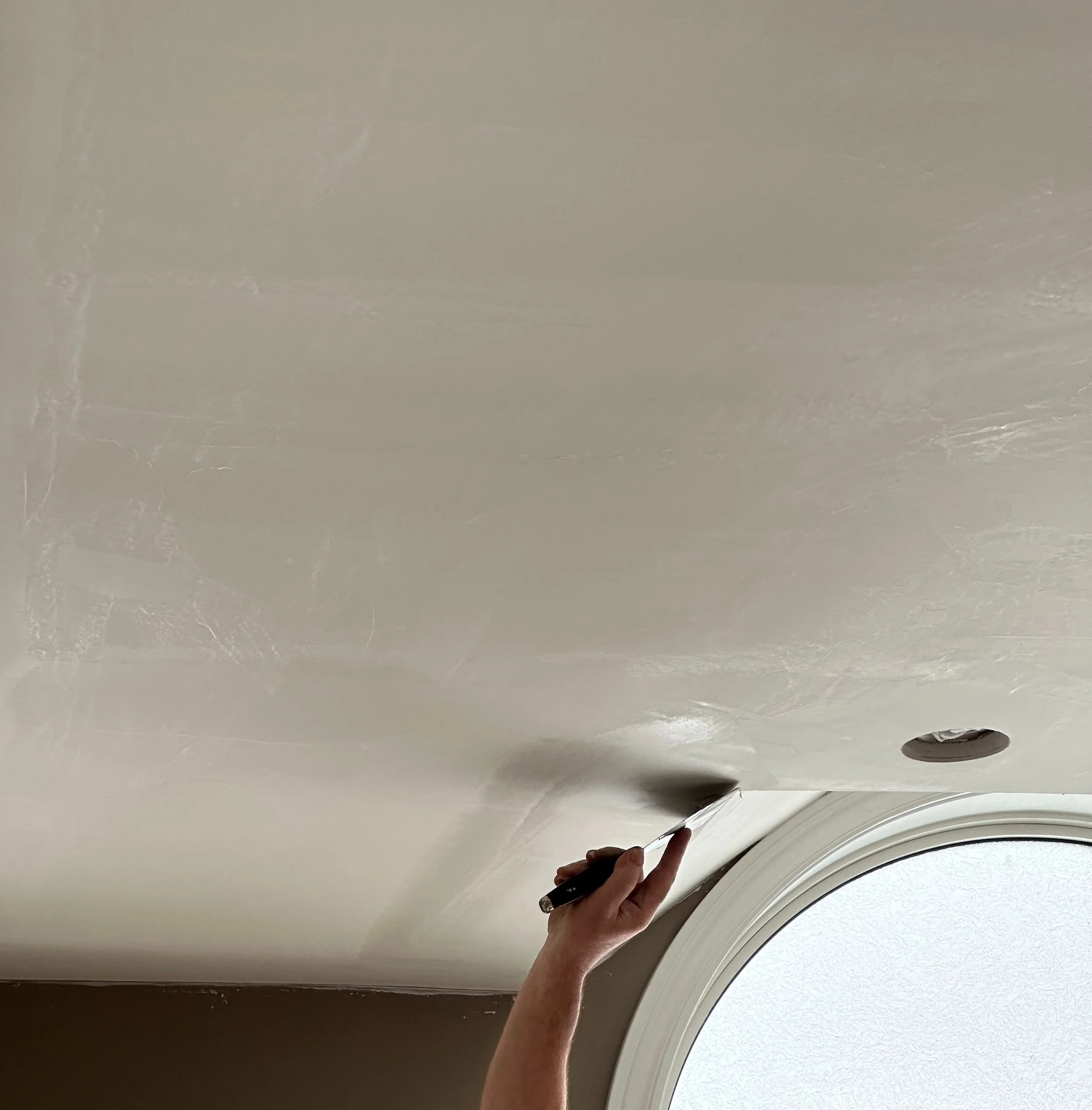 Person plaster repairing a ceiling.