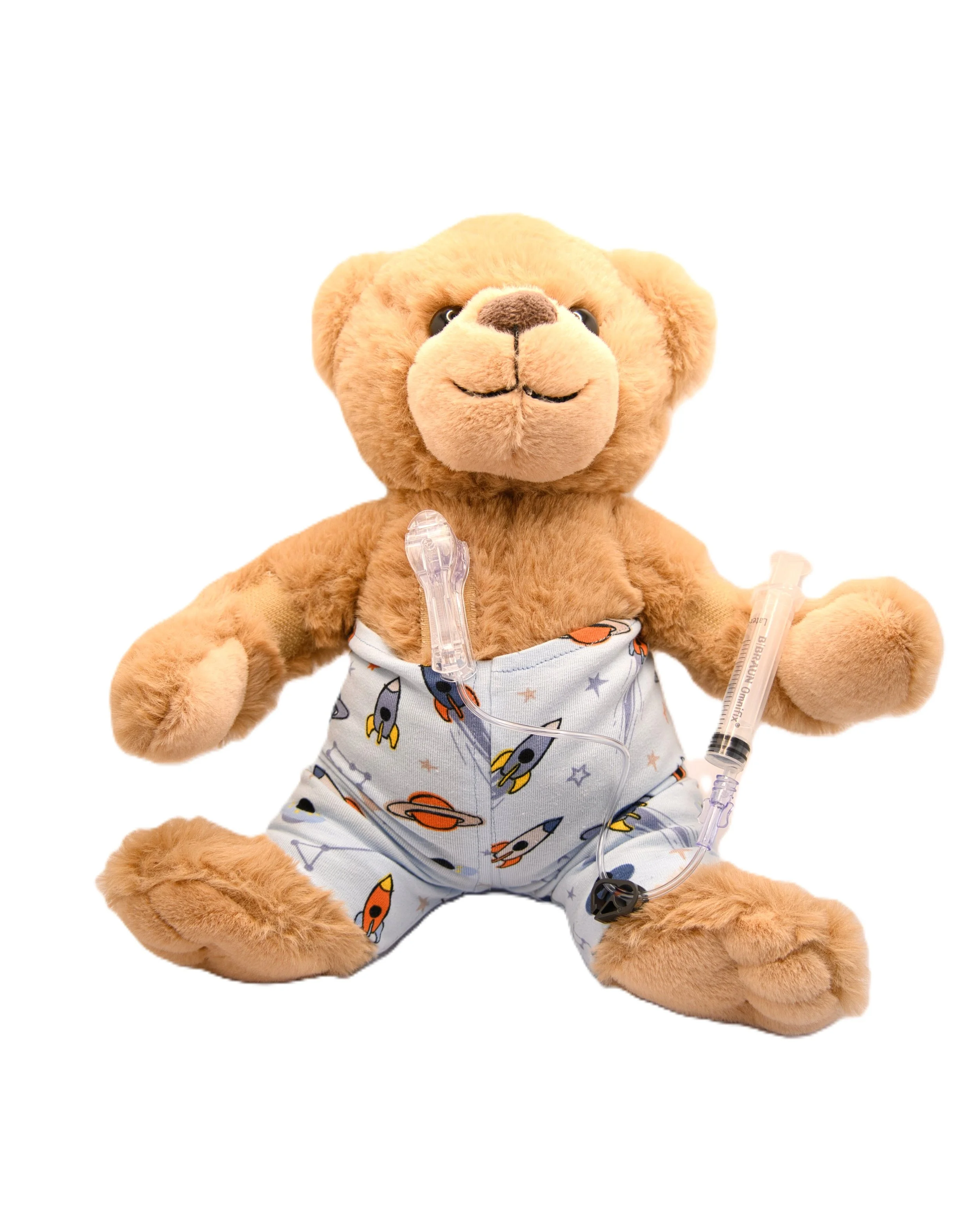 A plush teddy bear with tan fur, wearing space-themed pajamas, holding a medical IV line in its paw, against a white background.