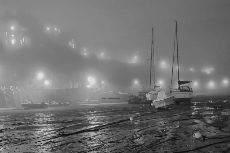 Boats at rest in the fog. Tenby harbour.