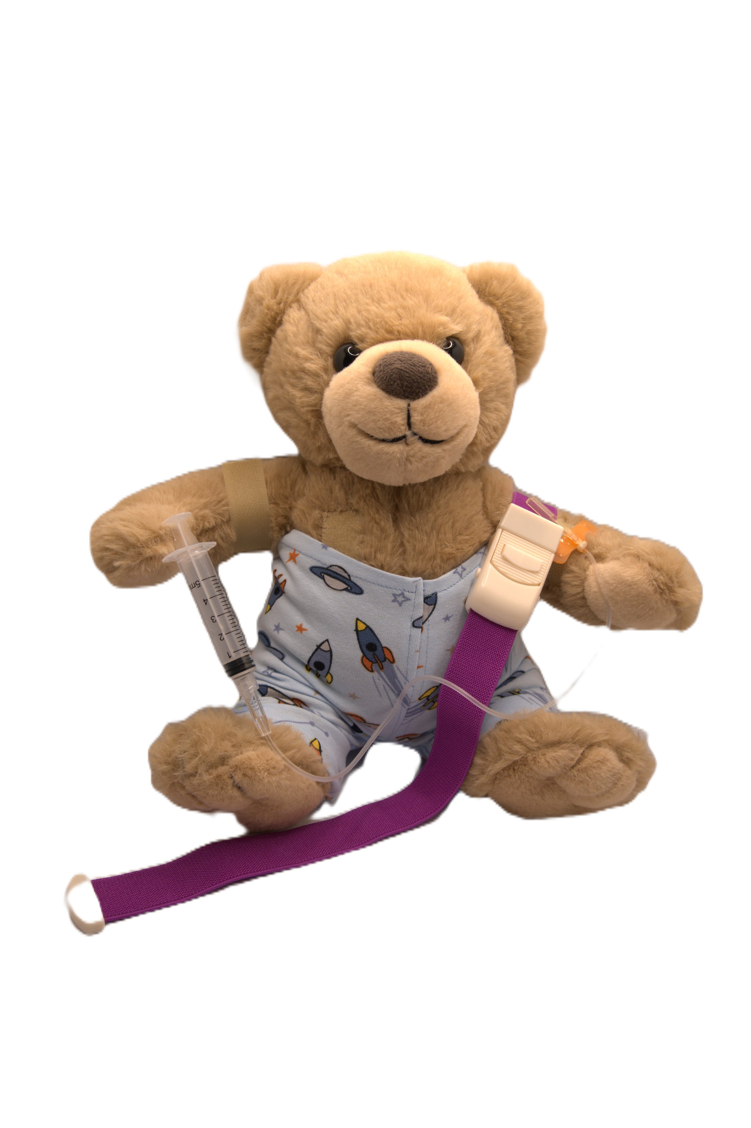 A plush teddy bear wearing space-themed pajamas and a purple strap, holding a syringe and medical supplies, sitting against a white background.