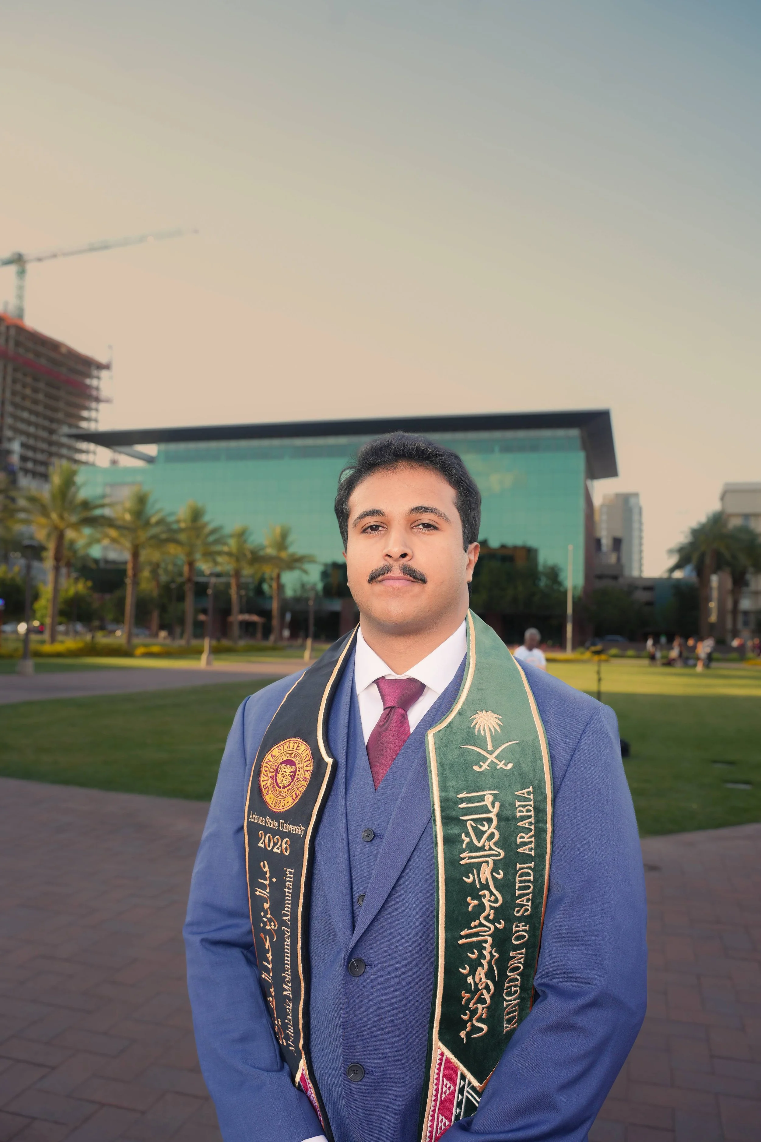 Male Arizona State Graduate climbing a horse