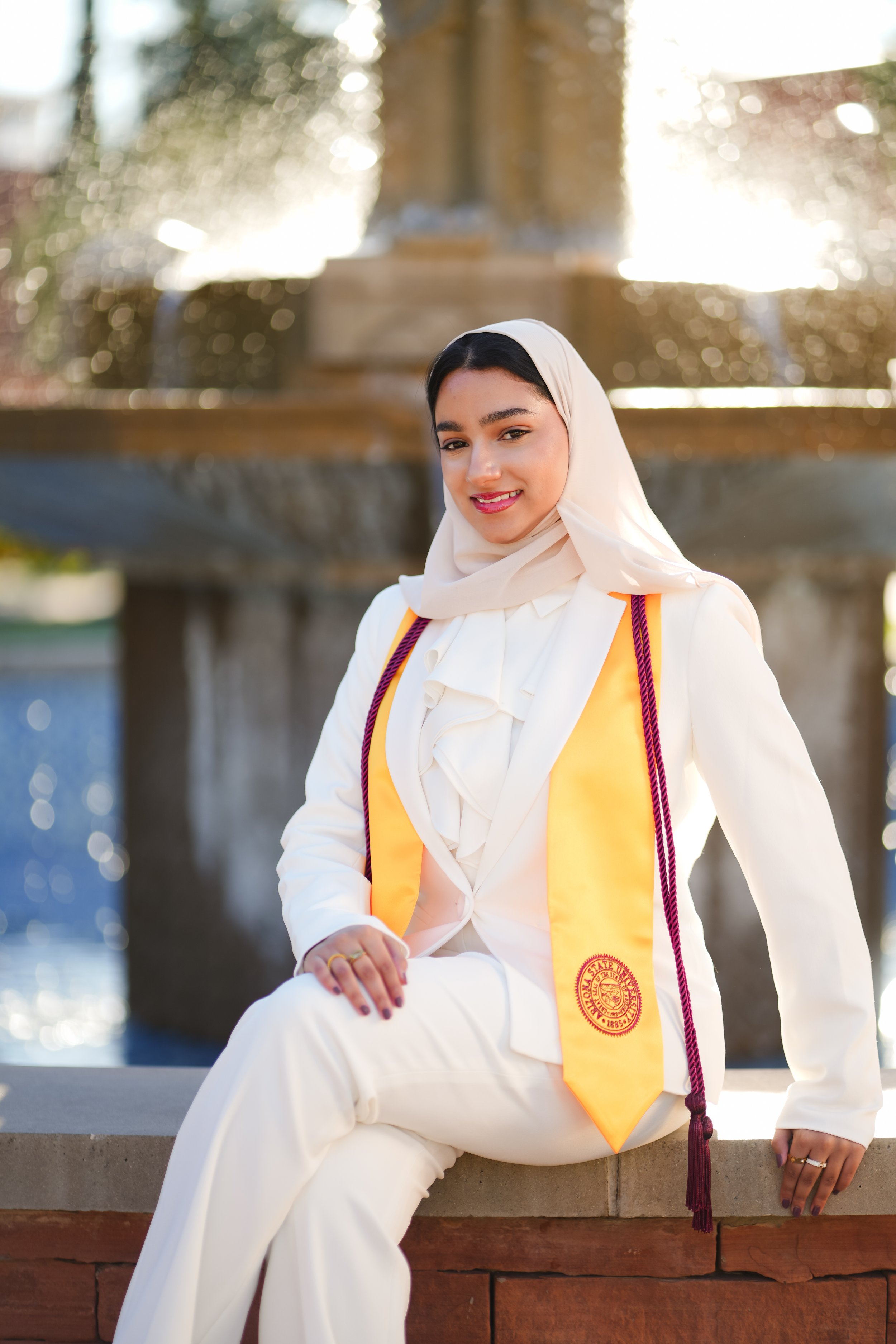 Black woman graduate exuding confidence and grace in front of architectural stairs in Scottsdale, Arizona. A proud moment in Phoenix, celebrating education and success.