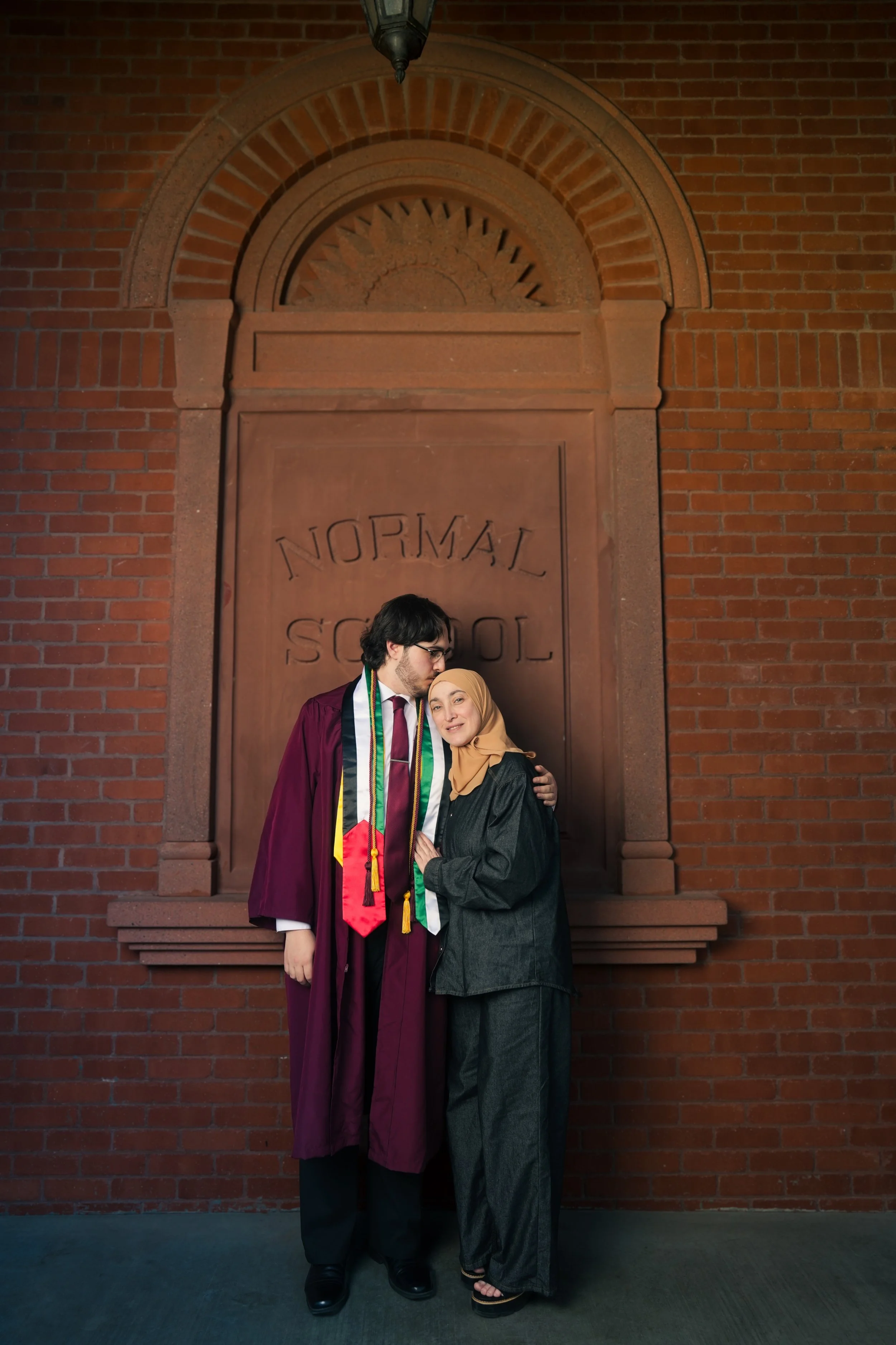 Male Arizona State Graduate climbing a horse