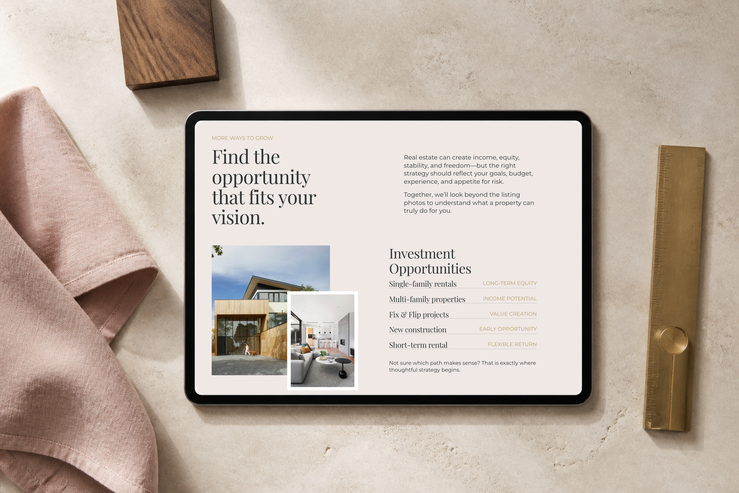A tablet displaying a real estate website surrounded by a pink cloth, a wooden block, and a gold ruler, on a beige surface.