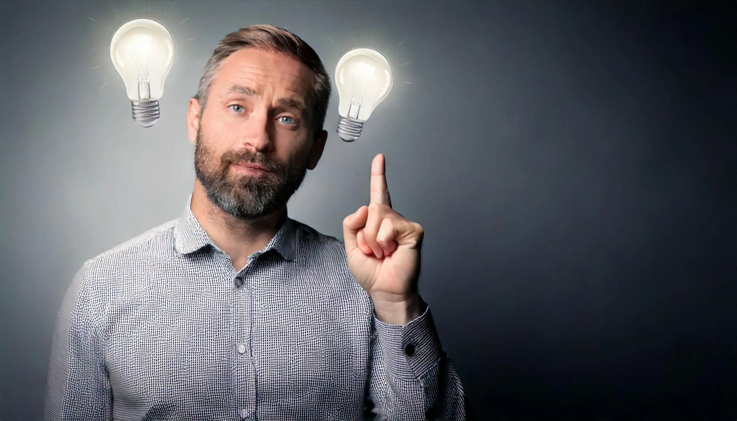 Homme avec barbe et chemise à petits motifs, levant le index avec deux ampoules allumées flottant au-dessus de sa tête.