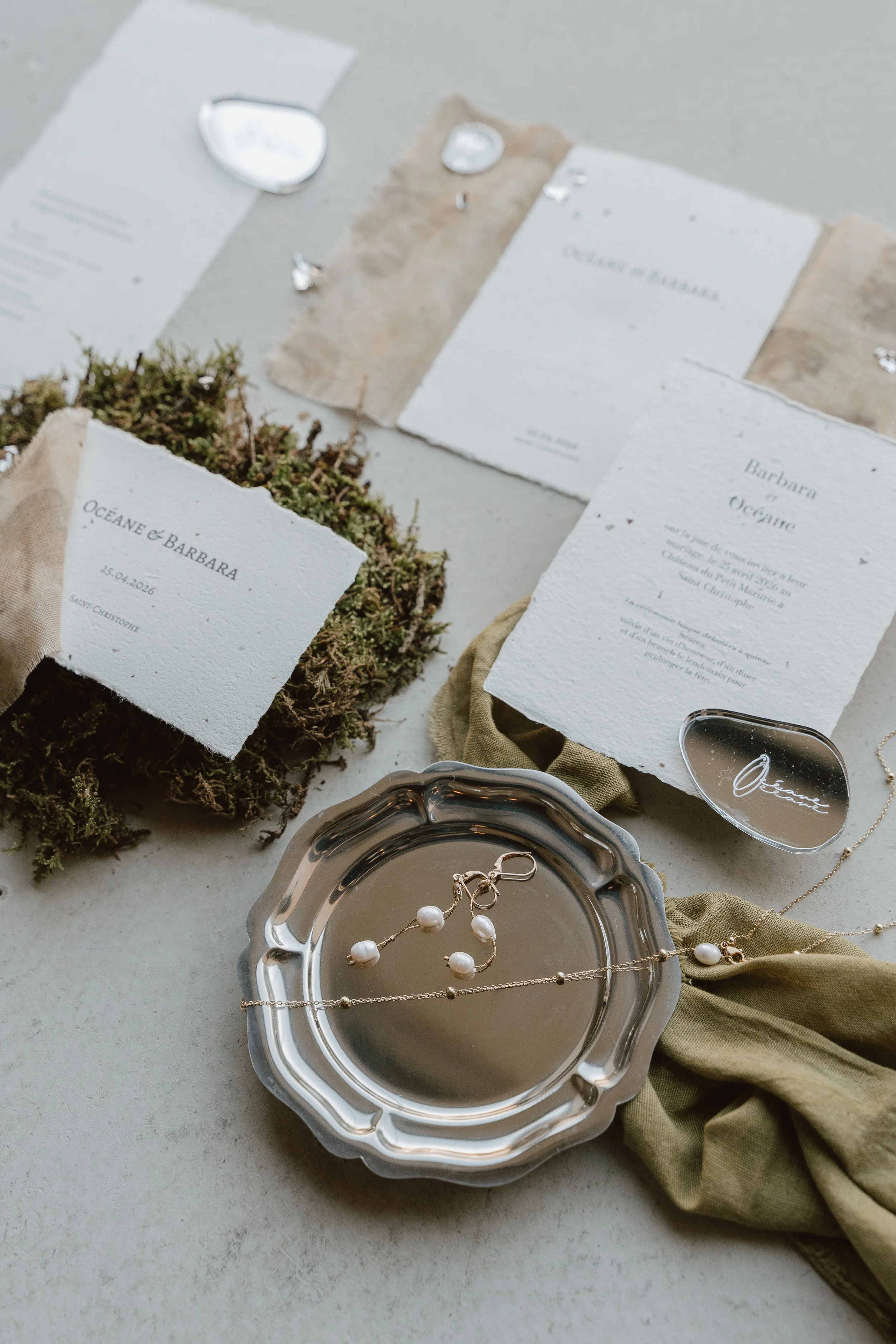 Invitation de mariage avec bijoux en perles, miroir, papier texturé et décoration naturelle
