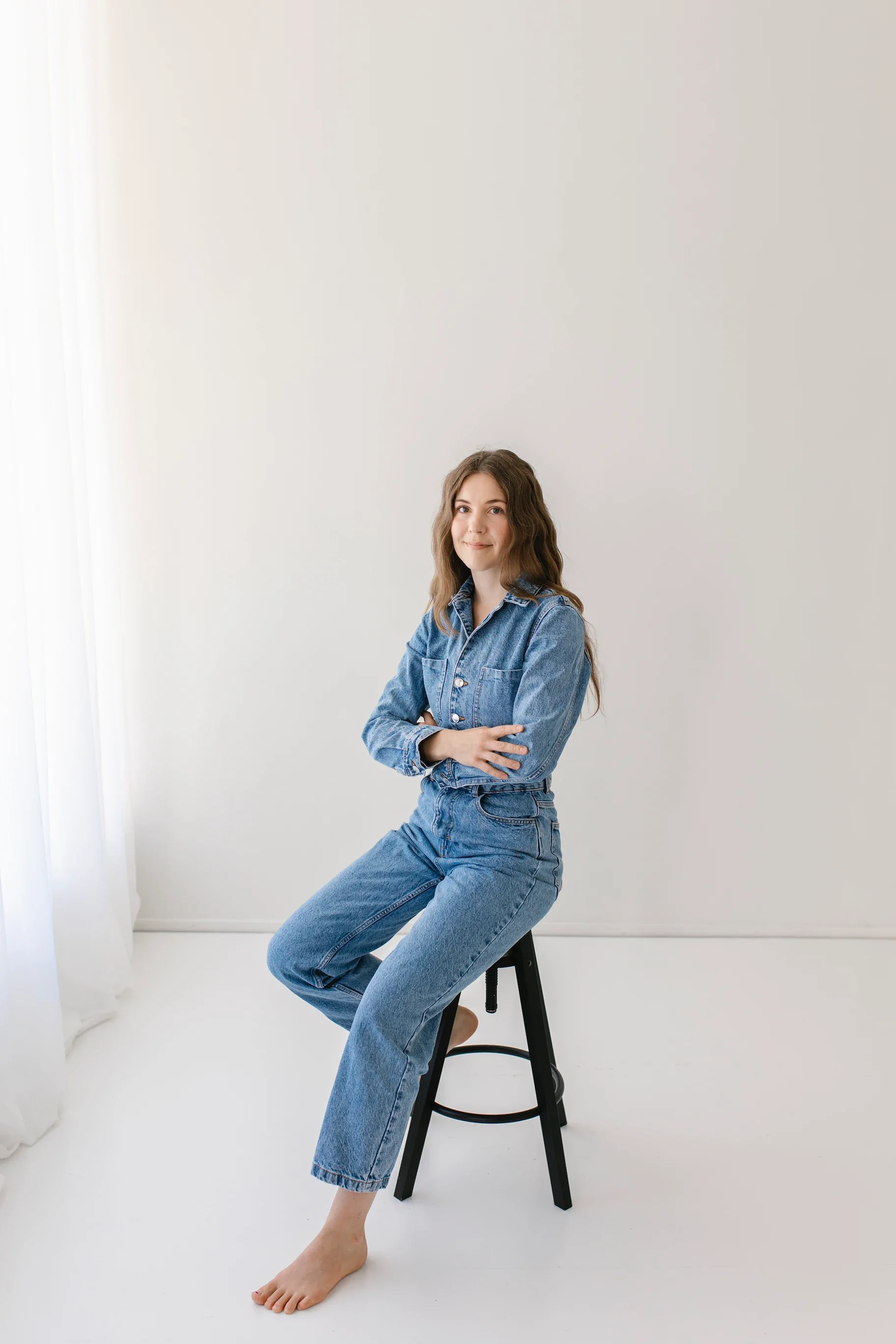 Farkkuasuinen verkkosivujutekijä istuu tuolilla